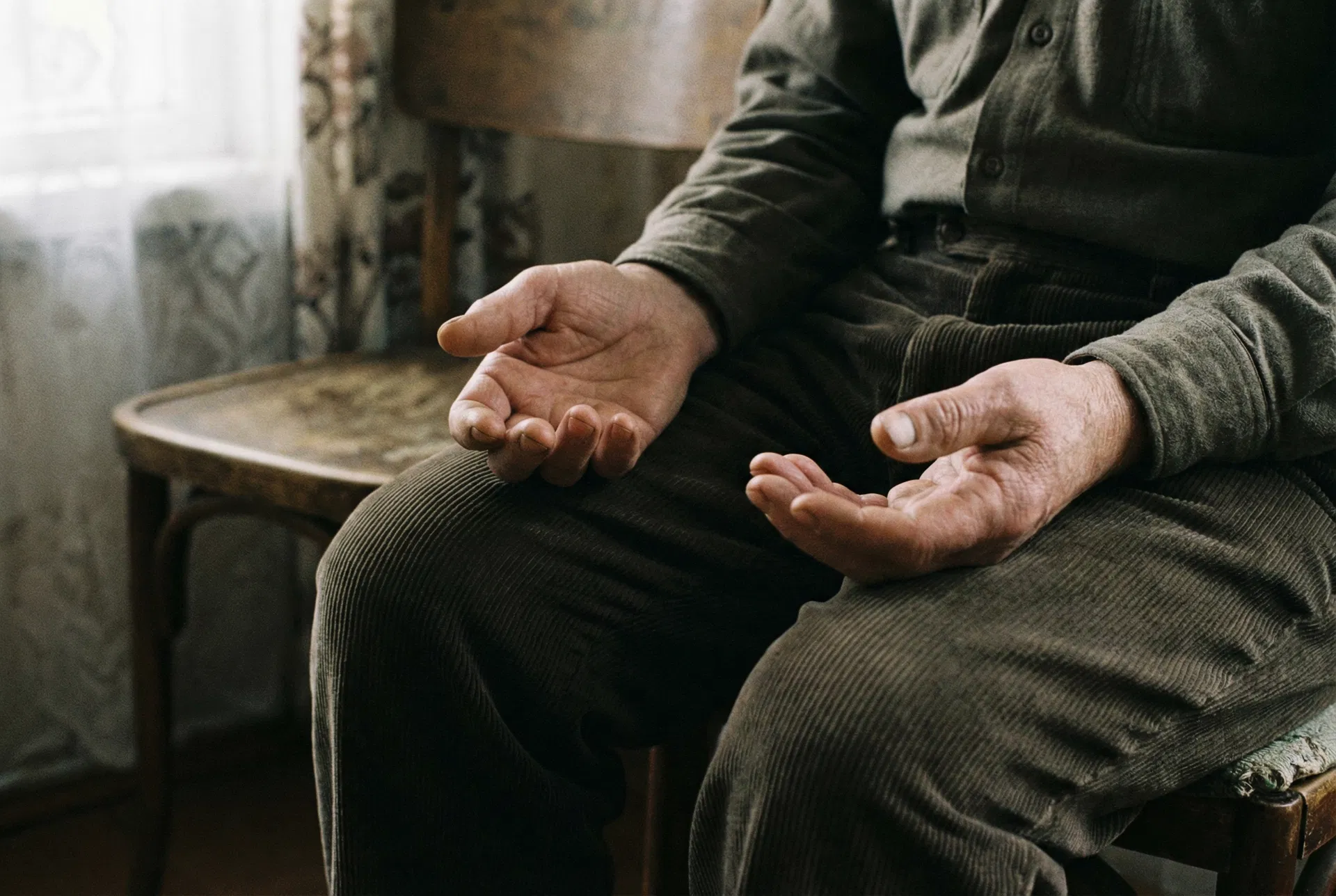 Mani aperte sul grembo, palmi verso l'alto — impotenza appresa e rassegnazione silenziosa