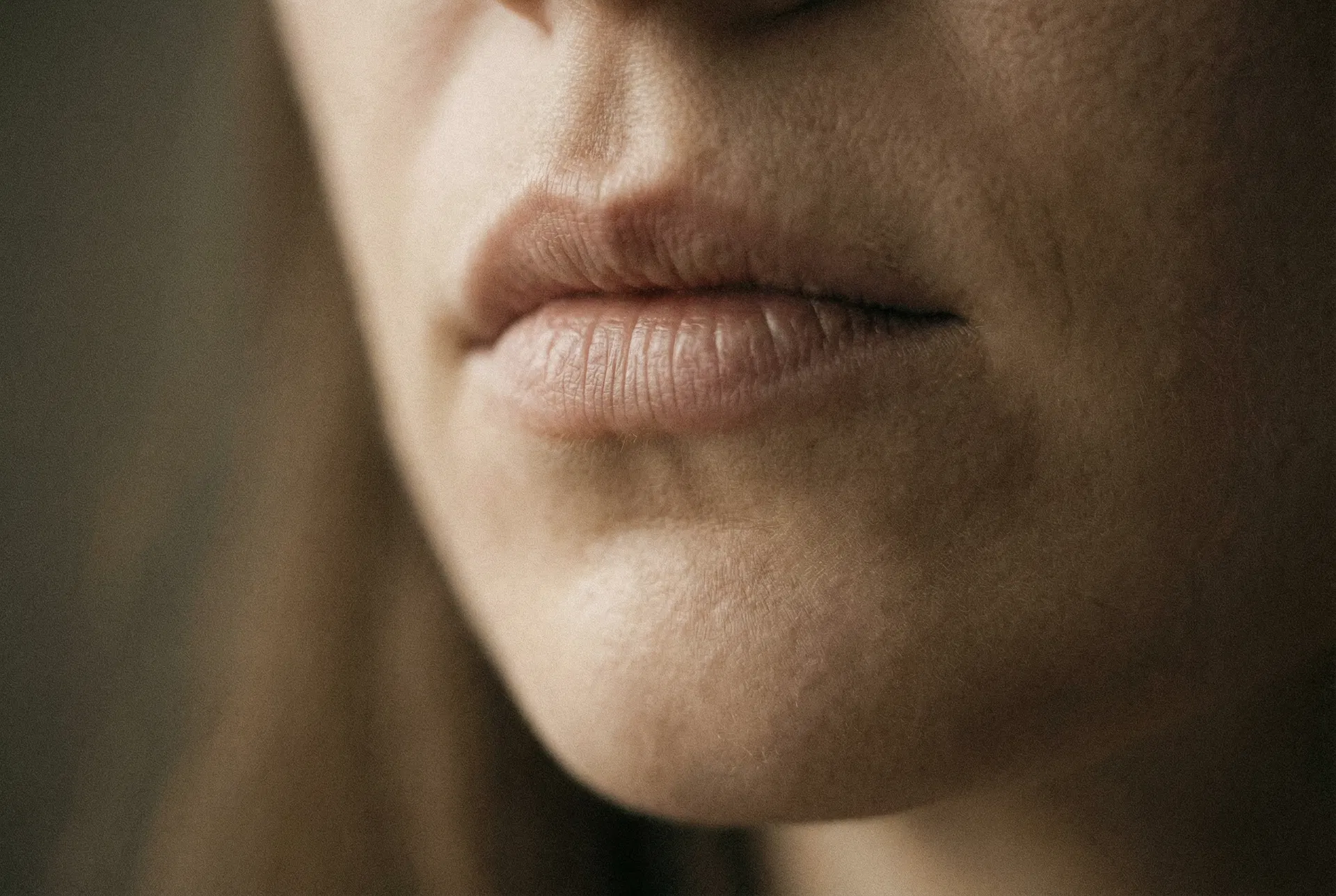 Primo piano di labbra chiuse — silenzio punitivo, parole trattenute e comunicazione bloccata