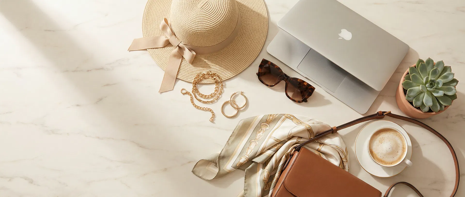 Curated lifestyle collection — sun hat, gold jewelry, sunglasses, laptop, and leather bag