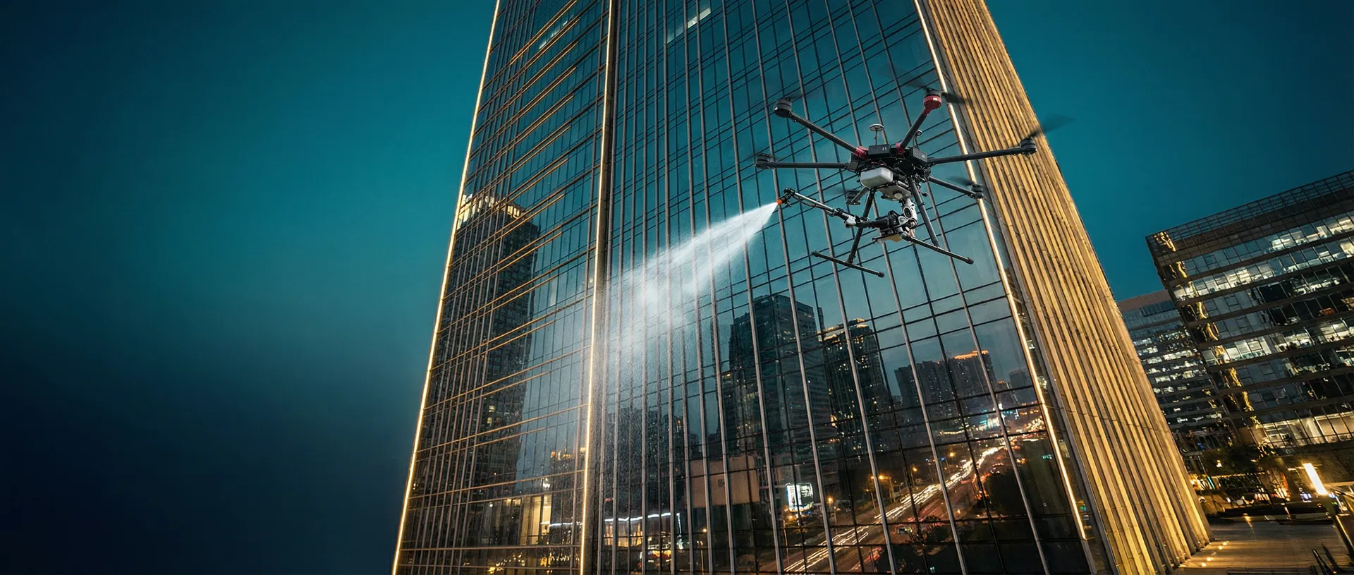 Drone cleaning a commercial high-rise building at dusk
