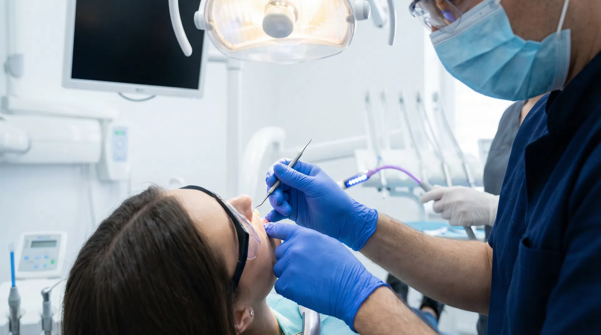 Professional dentist applying direct composite resin veneers to patient's teeth in modern dental clinic