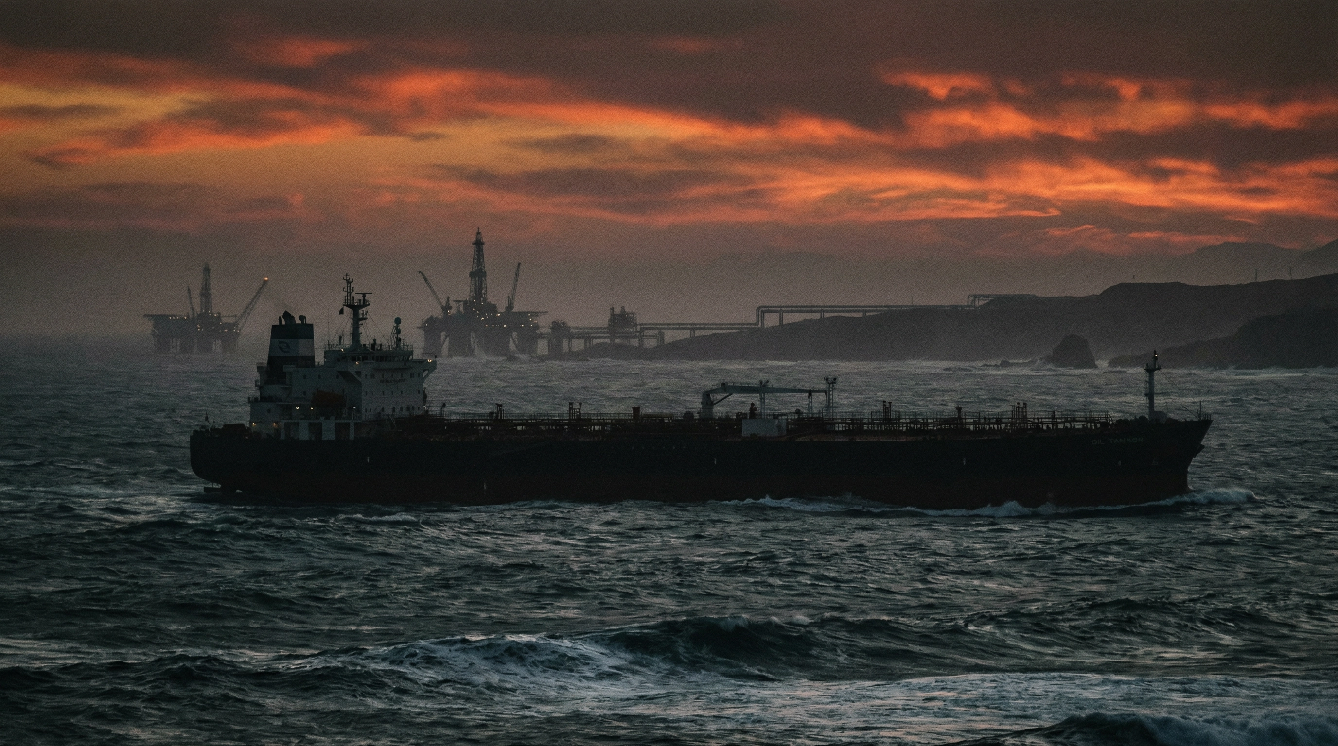 Oil tanker ship navigating turbulent waters with oil infrastructure silhouetted against dramatic sunset sky