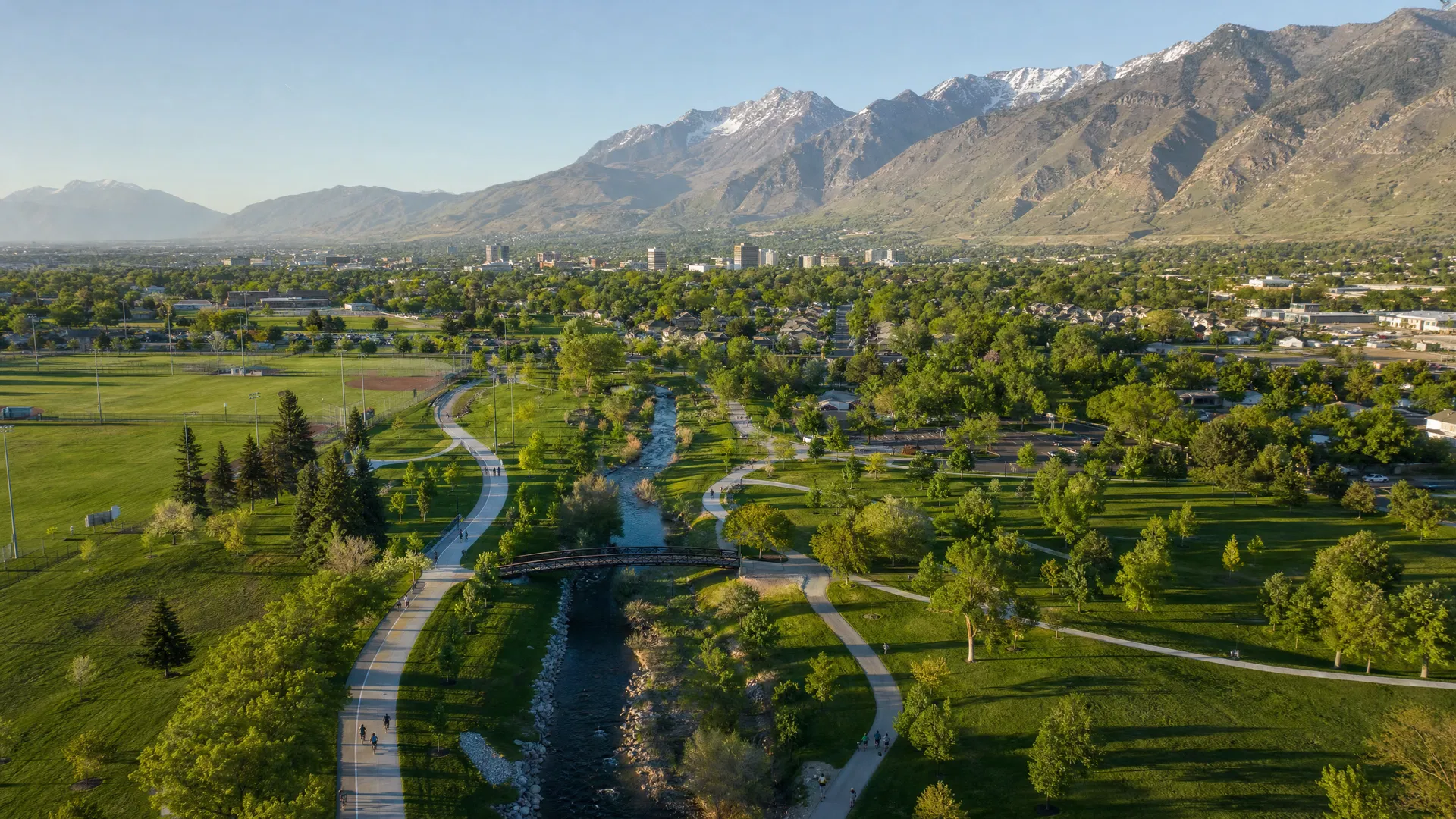 Aerial drone photograph of an urban trail system winding through Provo Utah parks connecting to the mountains