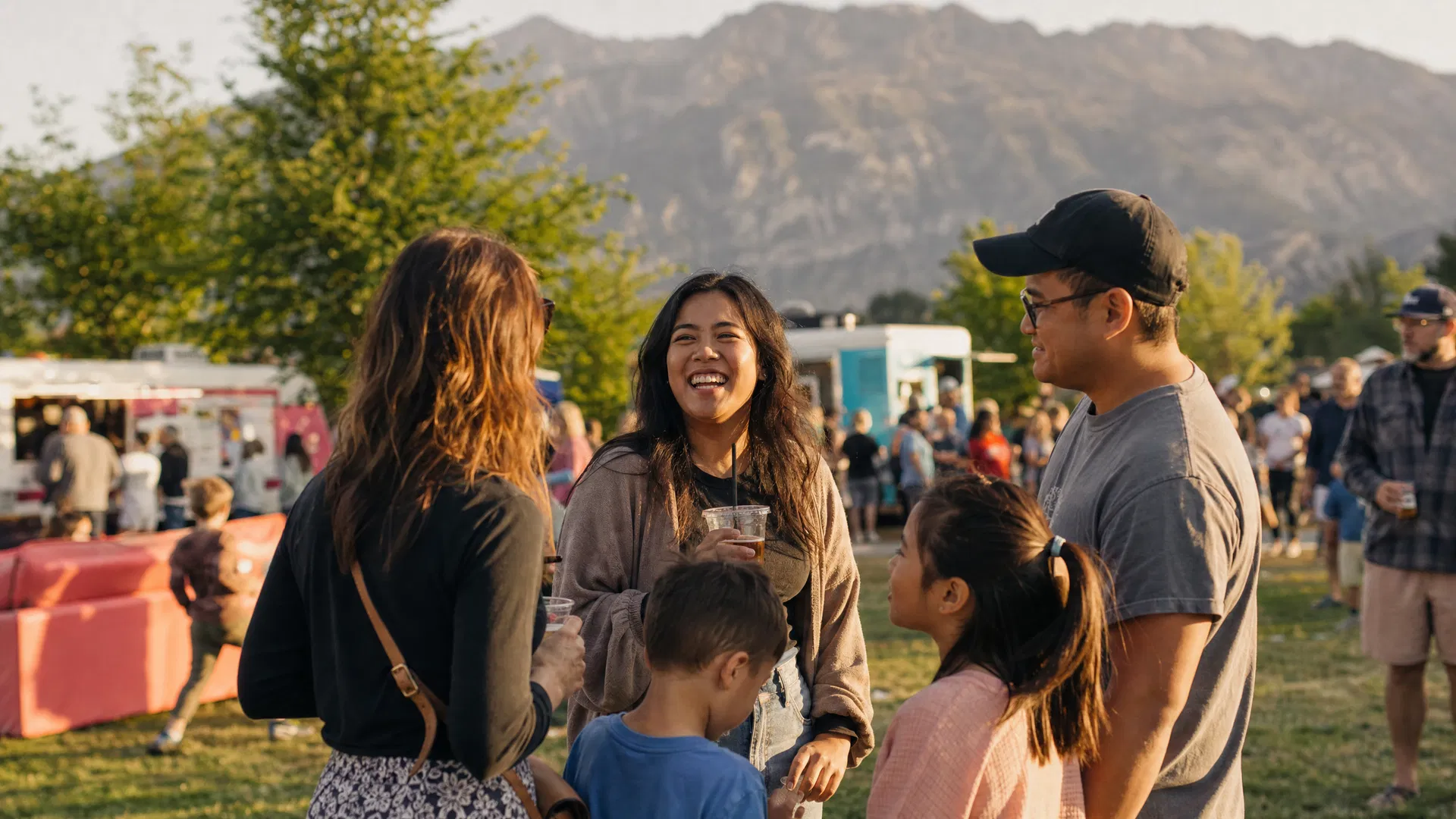 Diverse group of Provo Utah community members gathered at an outdoor event with mountains in the background