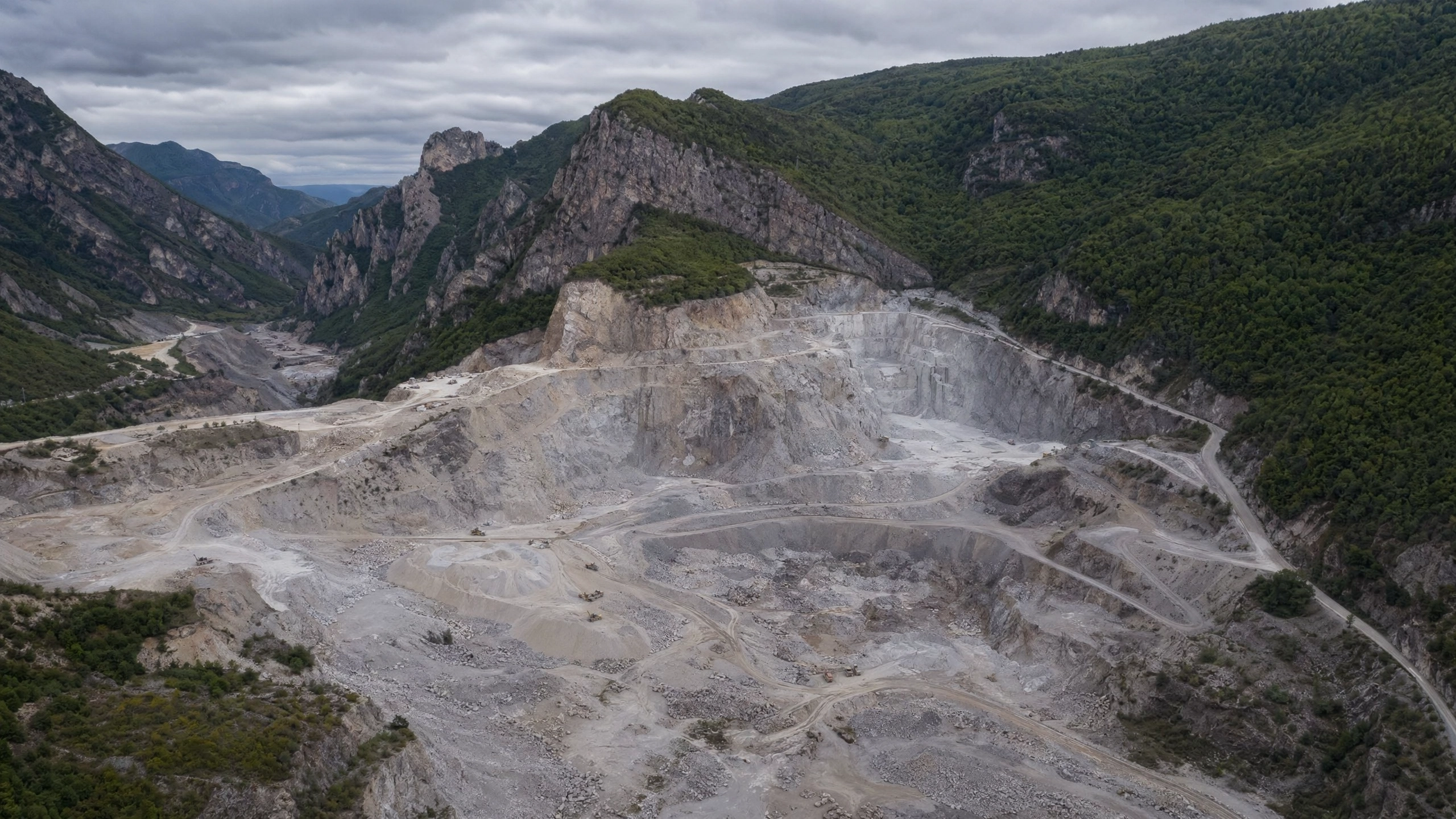 Aerial view of the damaged rock quarry — barren, scarred earth with exposed rock faces and rubble