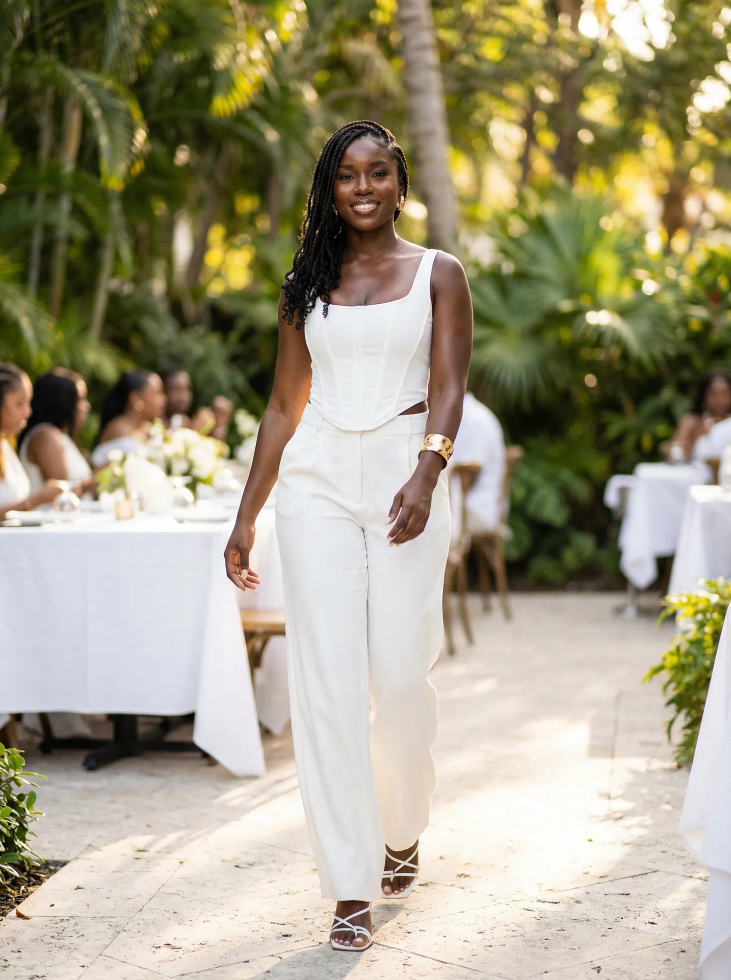 Woman in white corset top and trousers walking at event