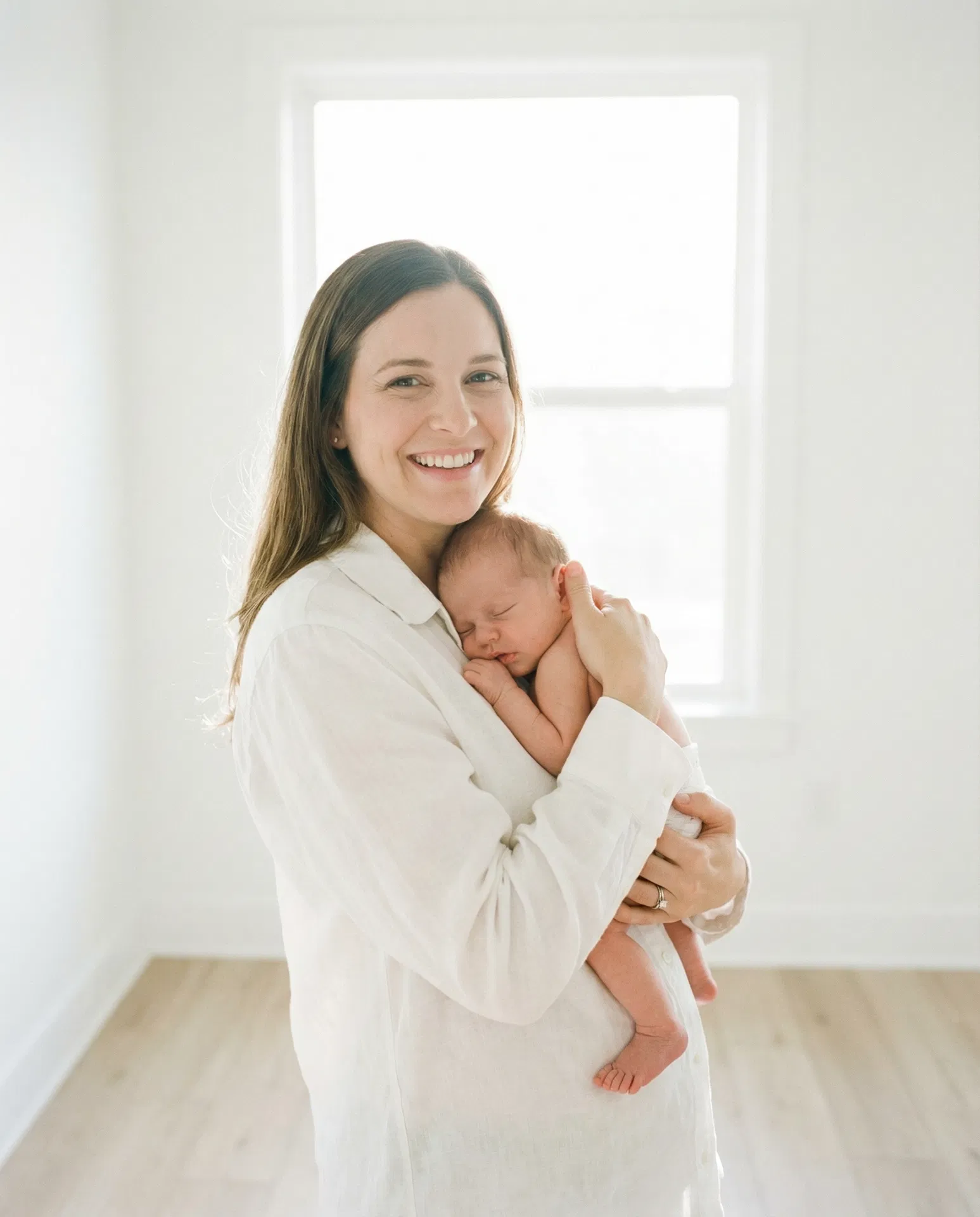 Happy mother holding her sleeping baby