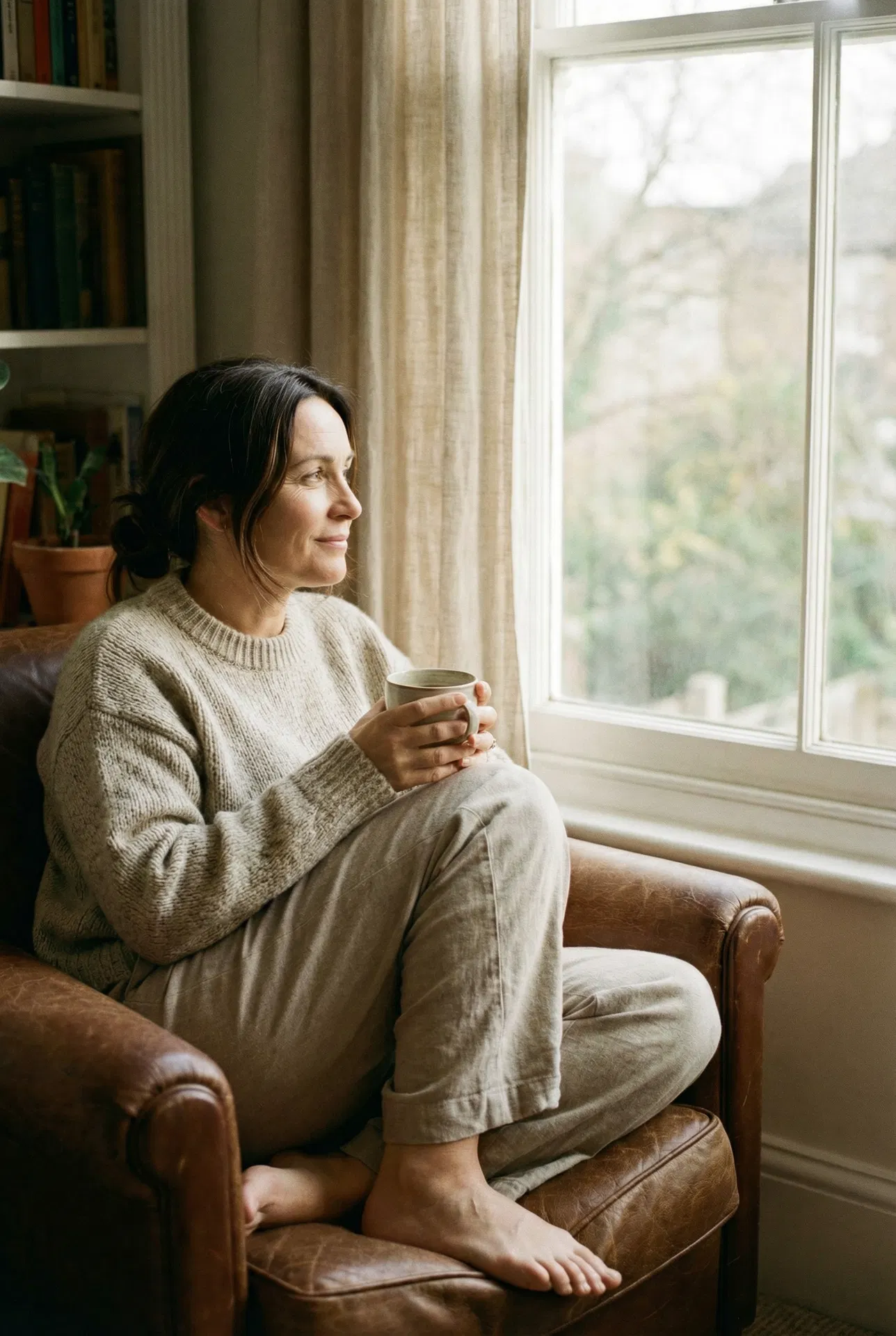 Woman sitting at kitchen table, quietly exhausted