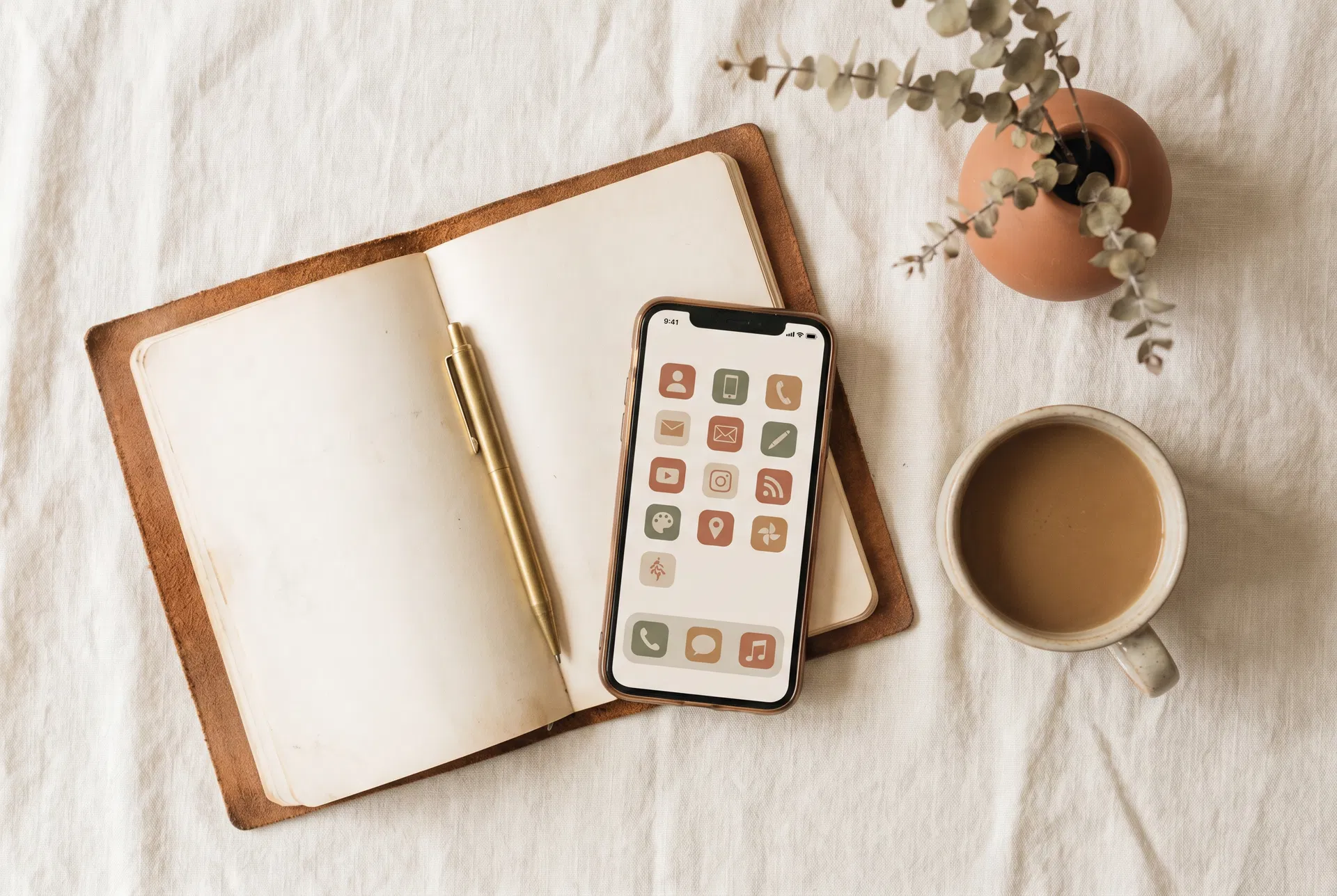 Smartphone with app icons alongside notebook and coffee