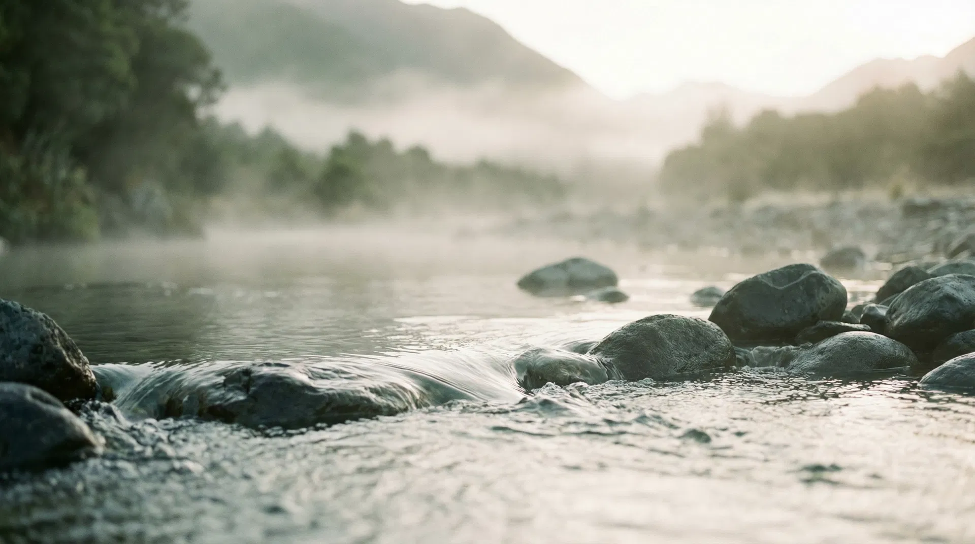 Crystal clear spring water flowing over volcanic rocks in New Zealand