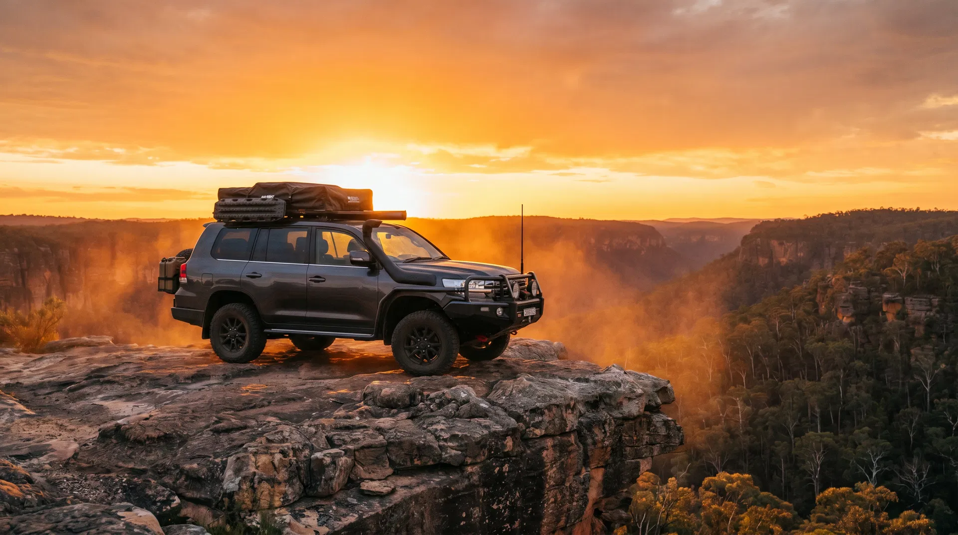 Fully loaded LandCruiser 200 Series on a cliff edge at golden hour