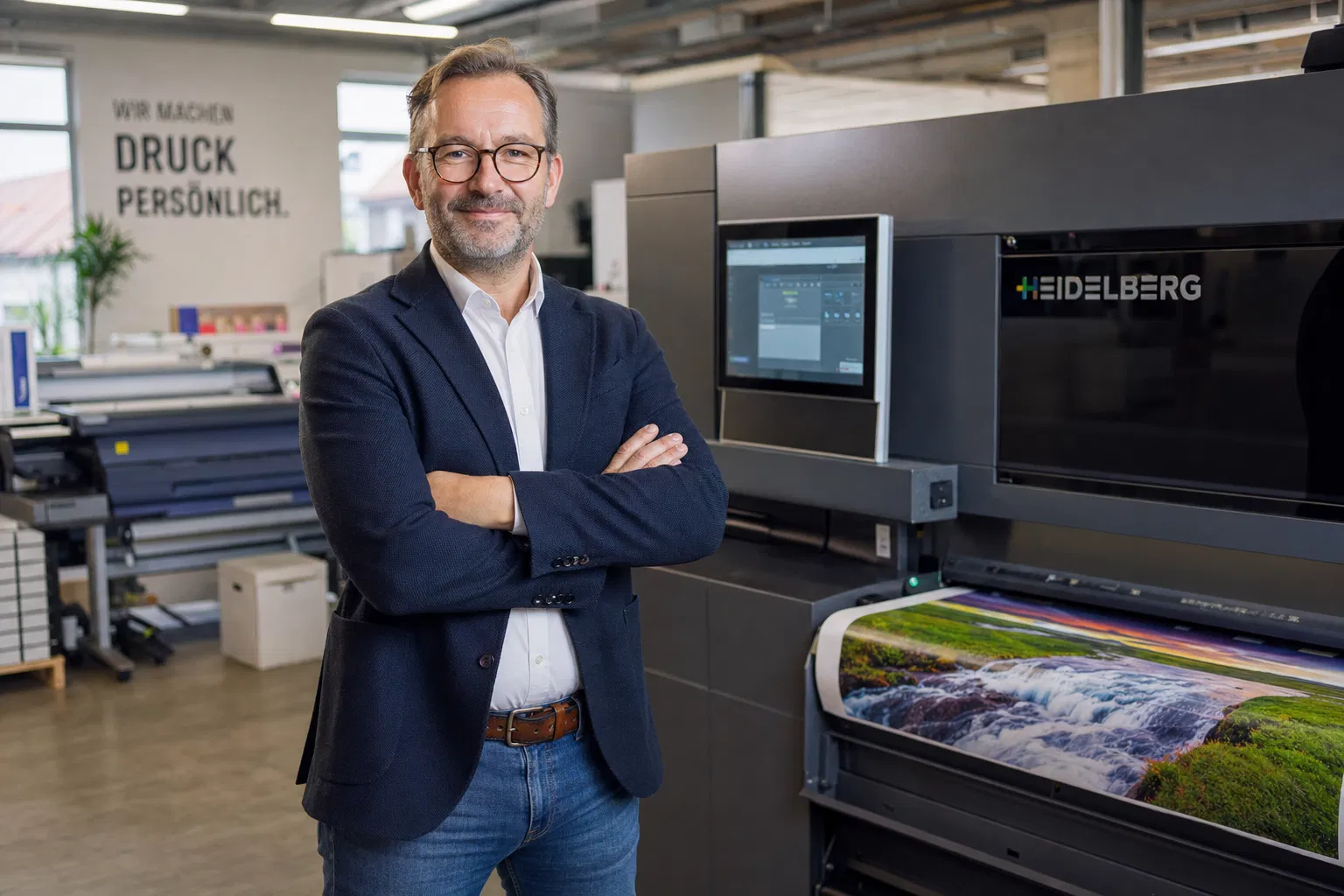 Druckerei-Inhaber steht neben Großformatdrucker in moderner Druckerei – Druckerei gründen 2026