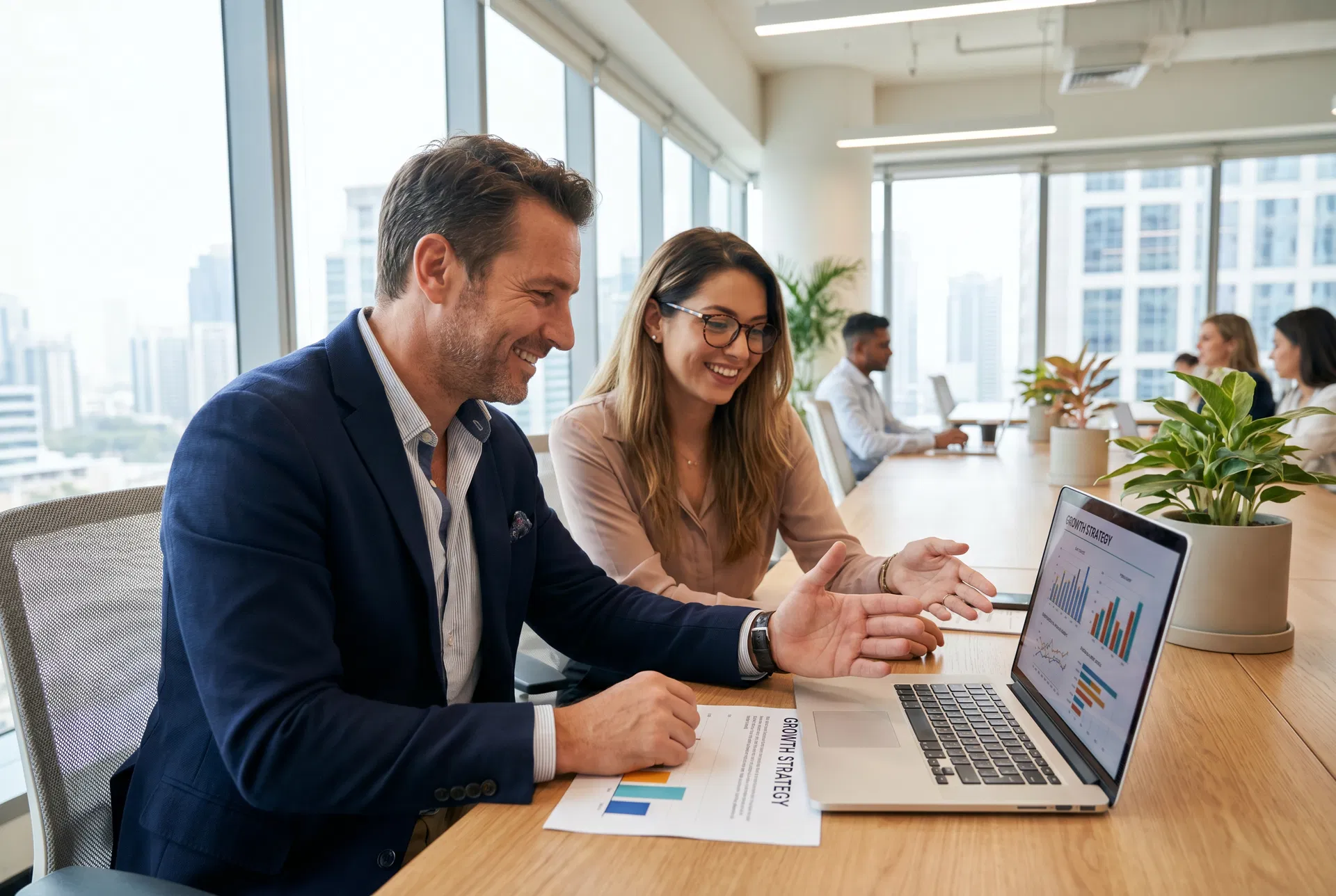 Erfahrener Gründungsberater bespricht mit einer angehenden Gründerin den Businessplan am Laptop.
