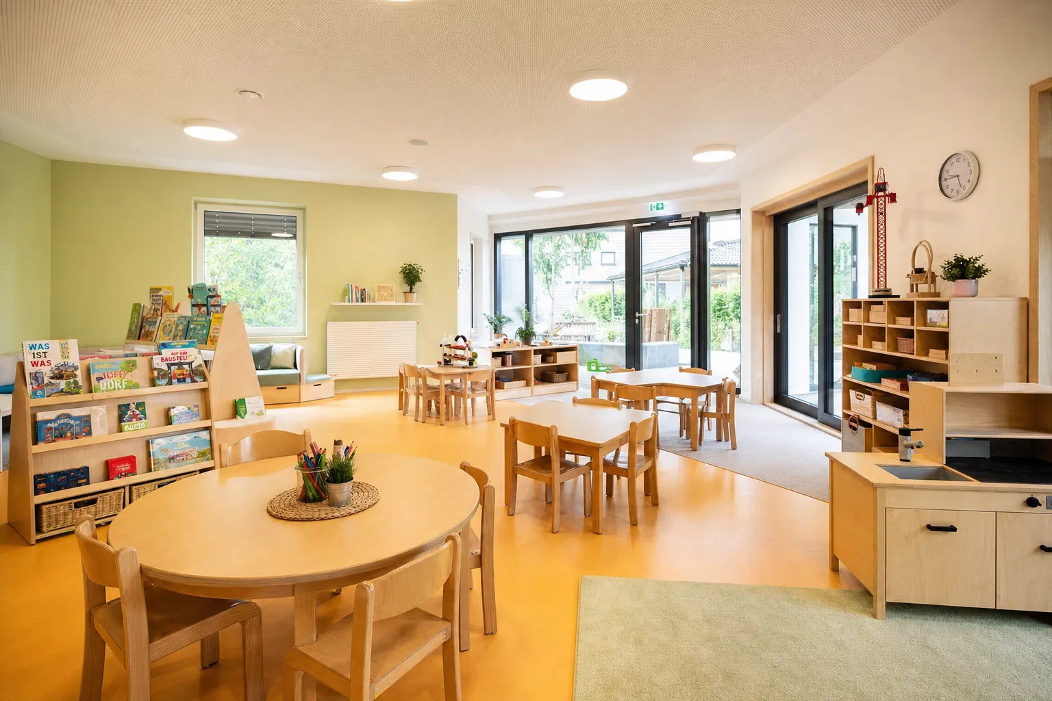 Kita grunden: Erzieherin spielt mit Kindern in heller, moderner Kindertagesstatte