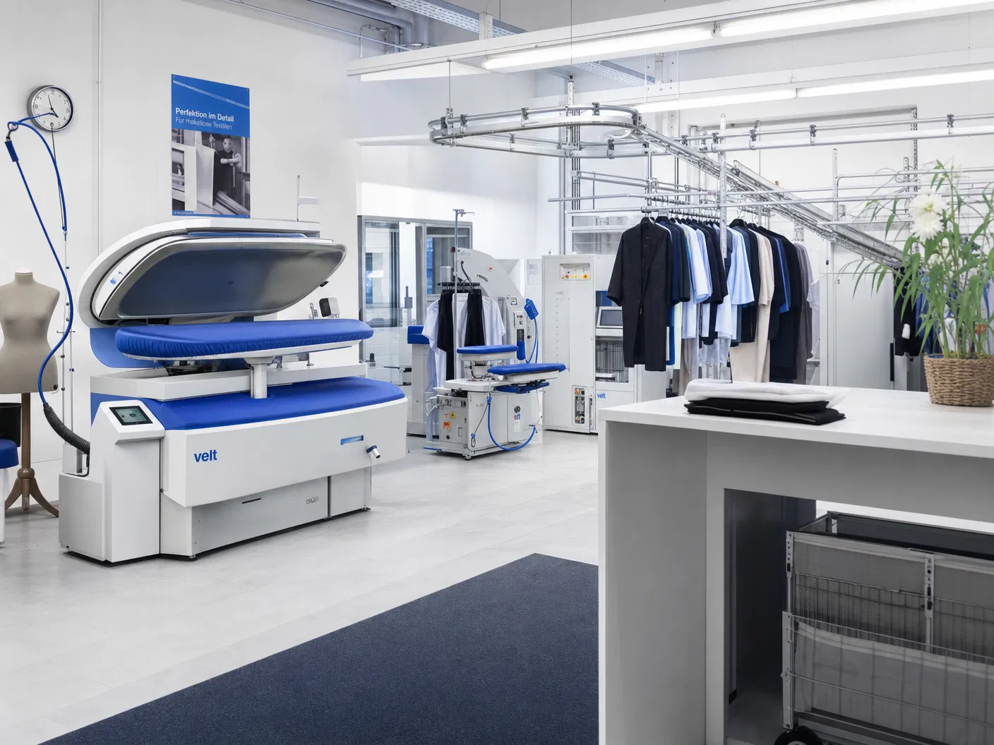 Professionelle Bügel- und Finishtechnik in einer Textilreinigung mit Kleiderförderband – Maschinenpark Textilreinigung