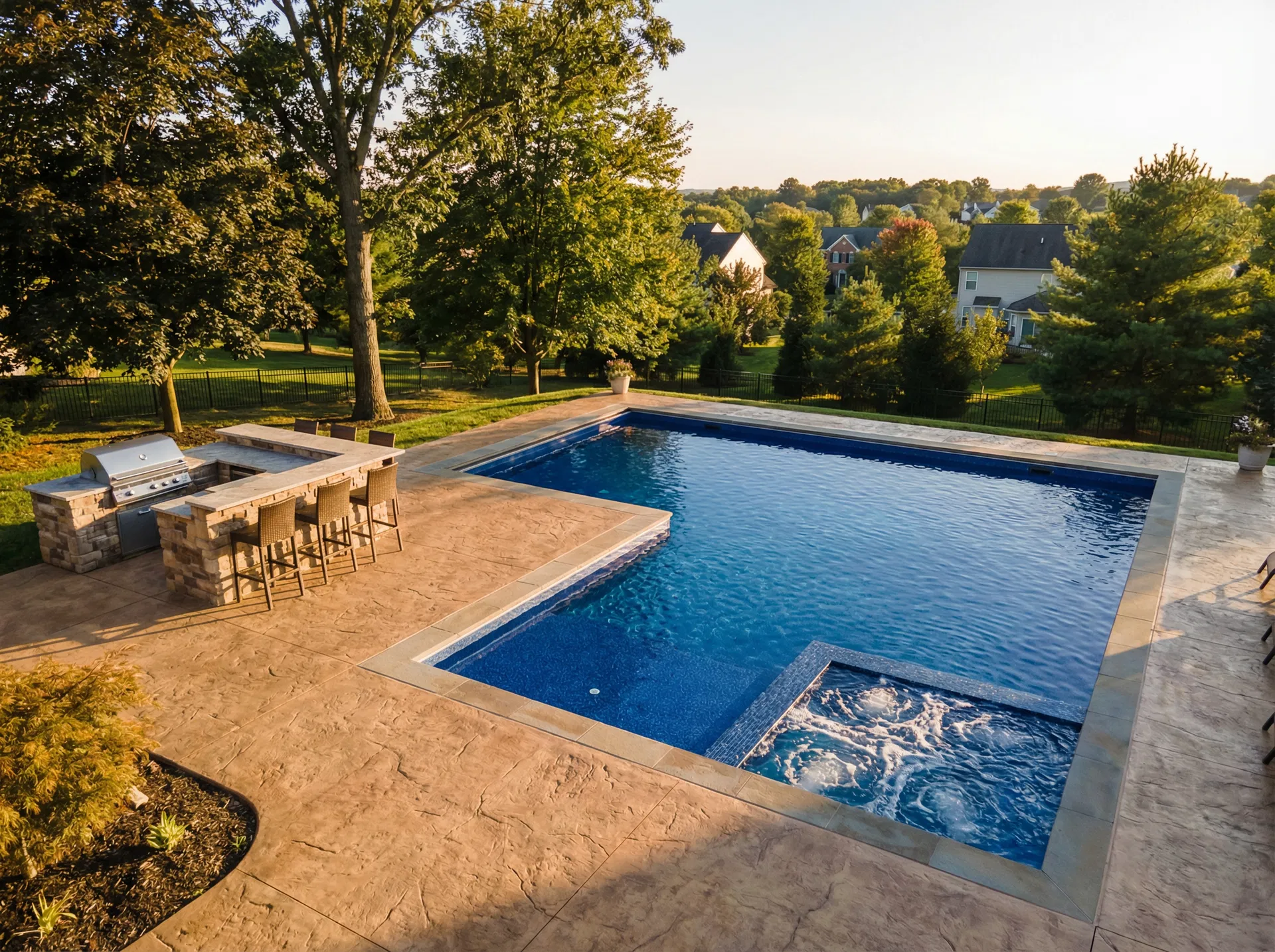 L-shaped pool with spa and outdoor kitchen from elevated angle