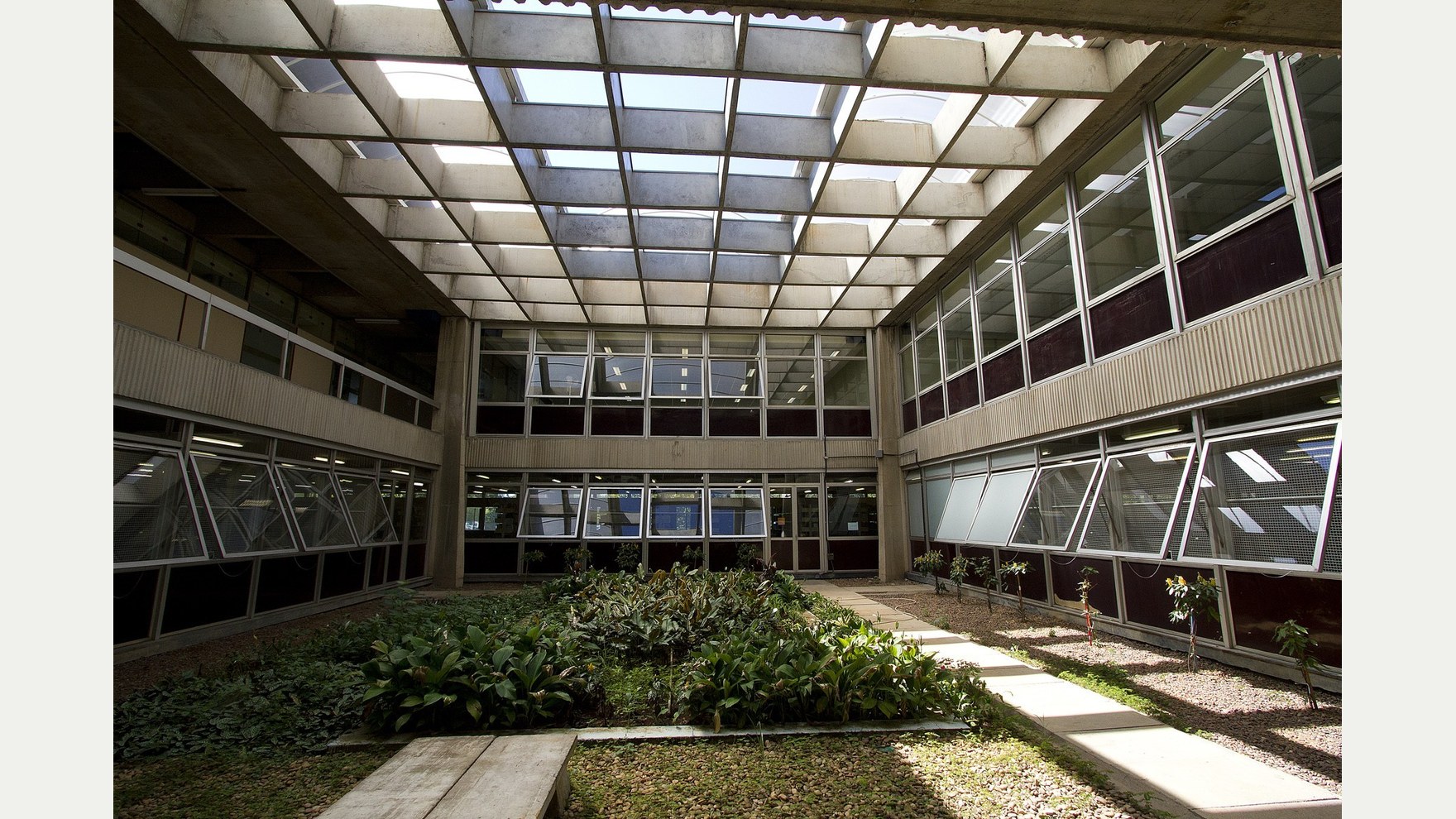 Interior do prédio da Engenharia Civil da Escola Politécnica da USP, com jardim interno e estrutura envidraçada