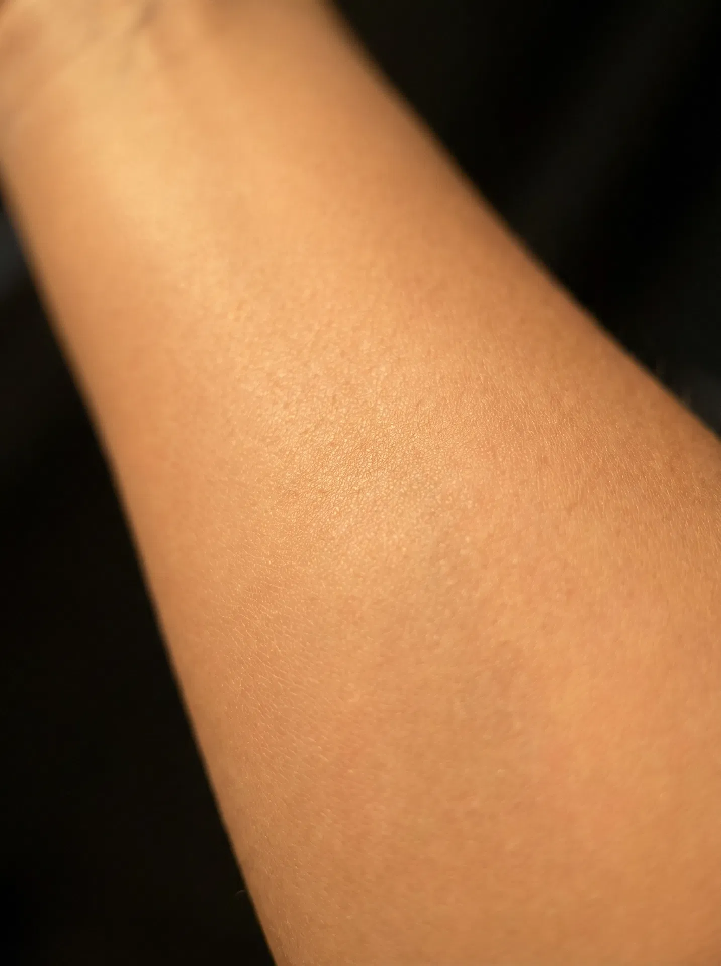 Ultra-macro close-up of firm, hydrated skin with warm golden lighting