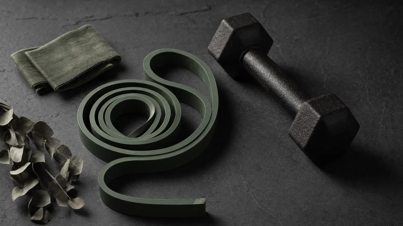 Set of colorful resistance bands and a yoga mat in a sunlit home gym corner
