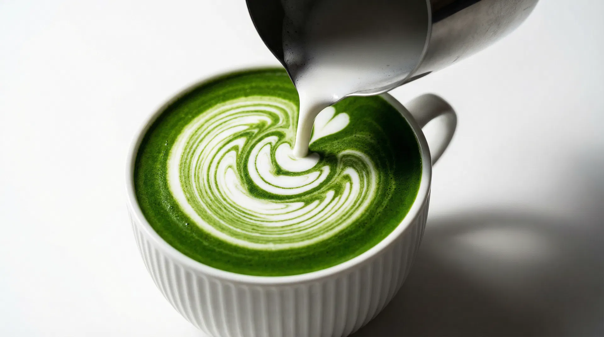 MATCHO signature matcha latte with beautiful latte art being poured