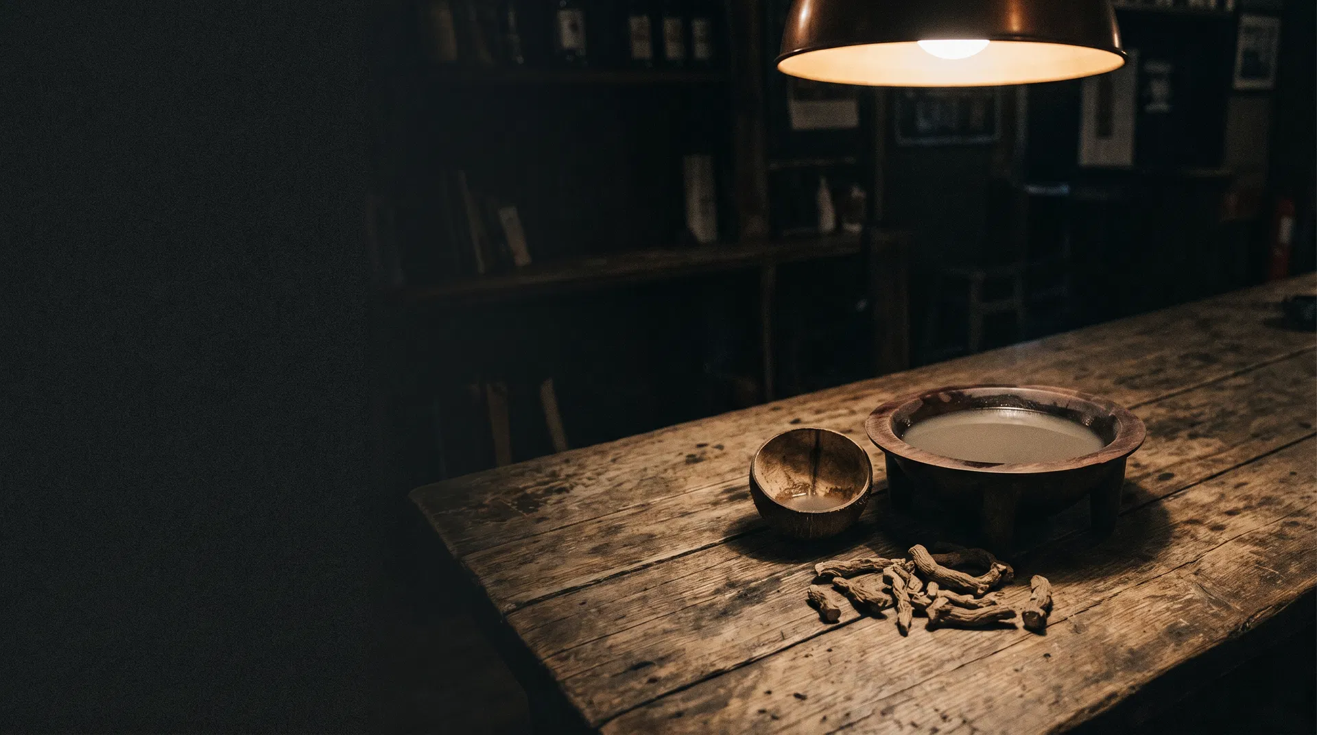 Traditional kava bowl and root on a worn wooden table