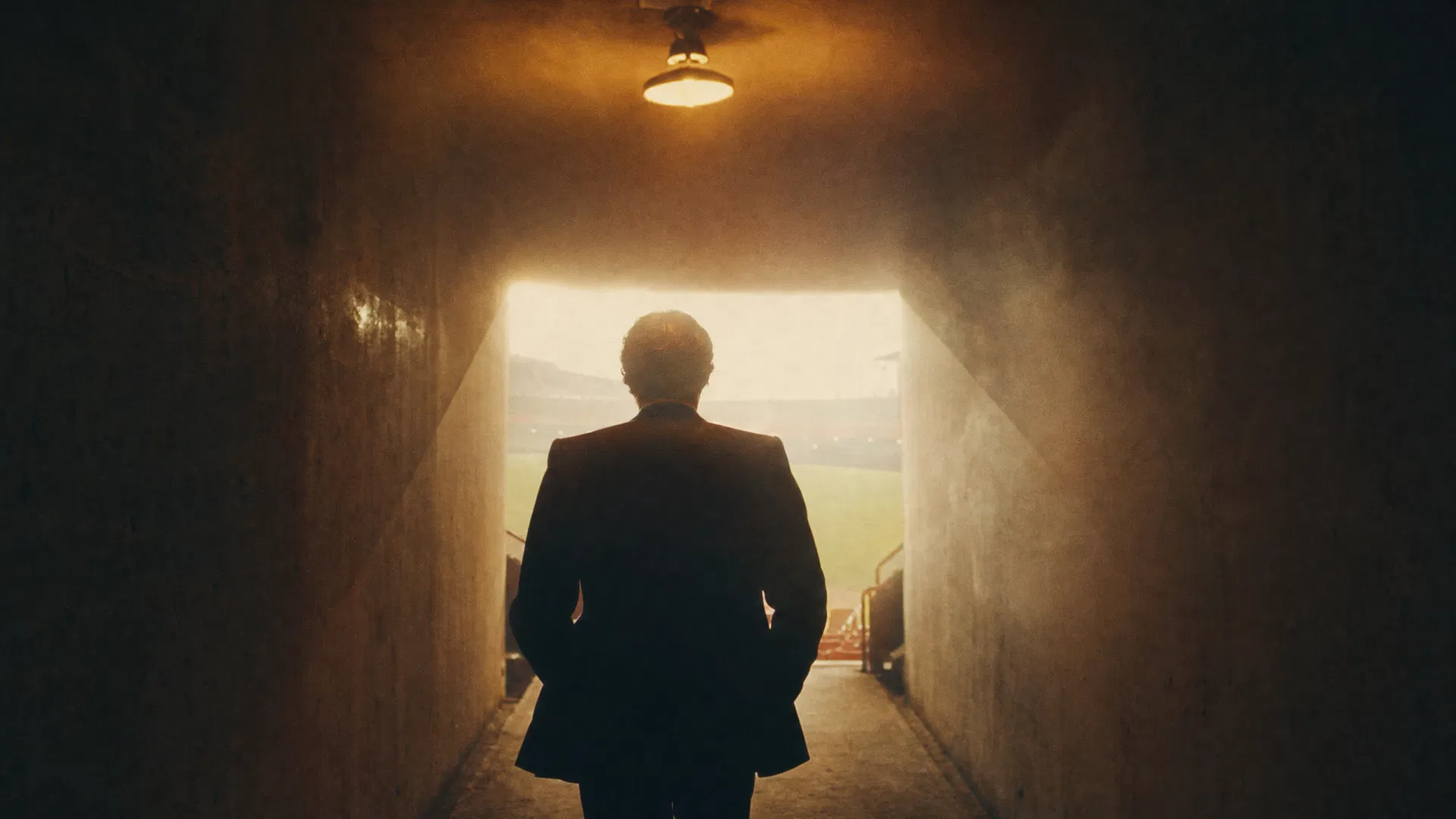 Free Agents key art — a man in a suit stands at the mouth of a stadium tunnel, looking out toward the field