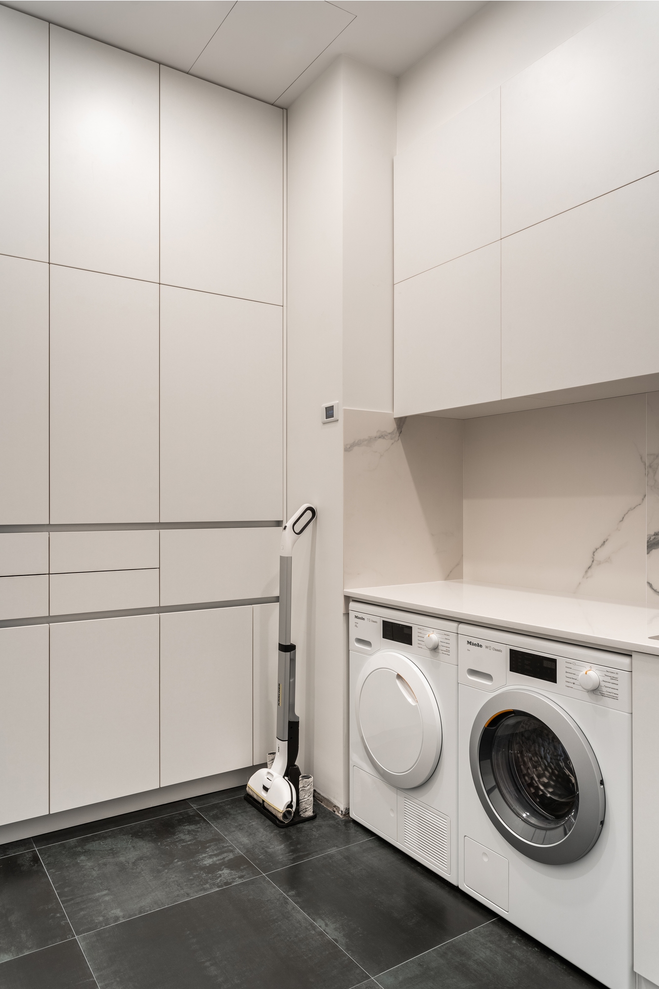 Современная прачечная с белой мебелью