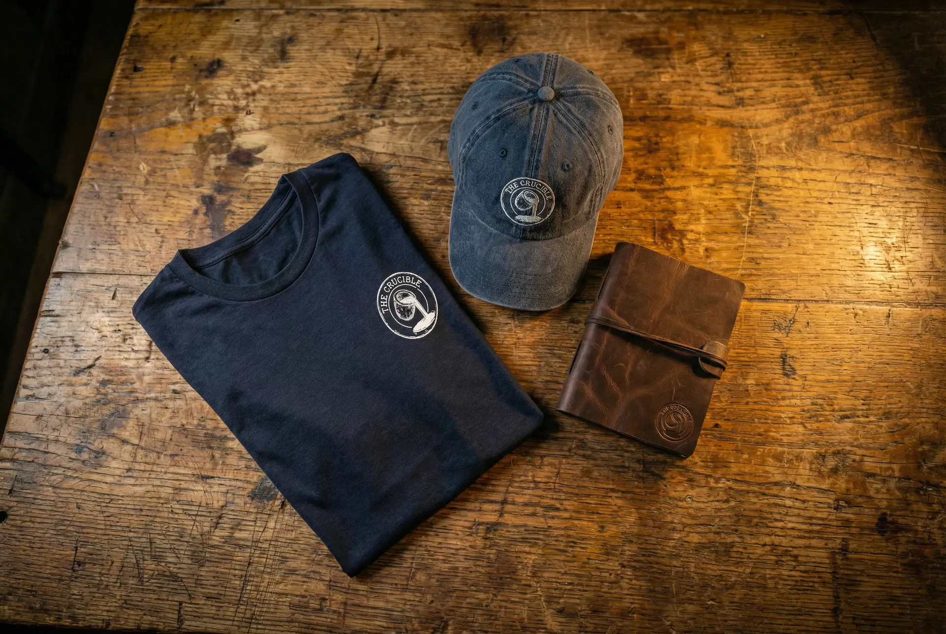 The Crucible collection — shirt, hat, and leather journal