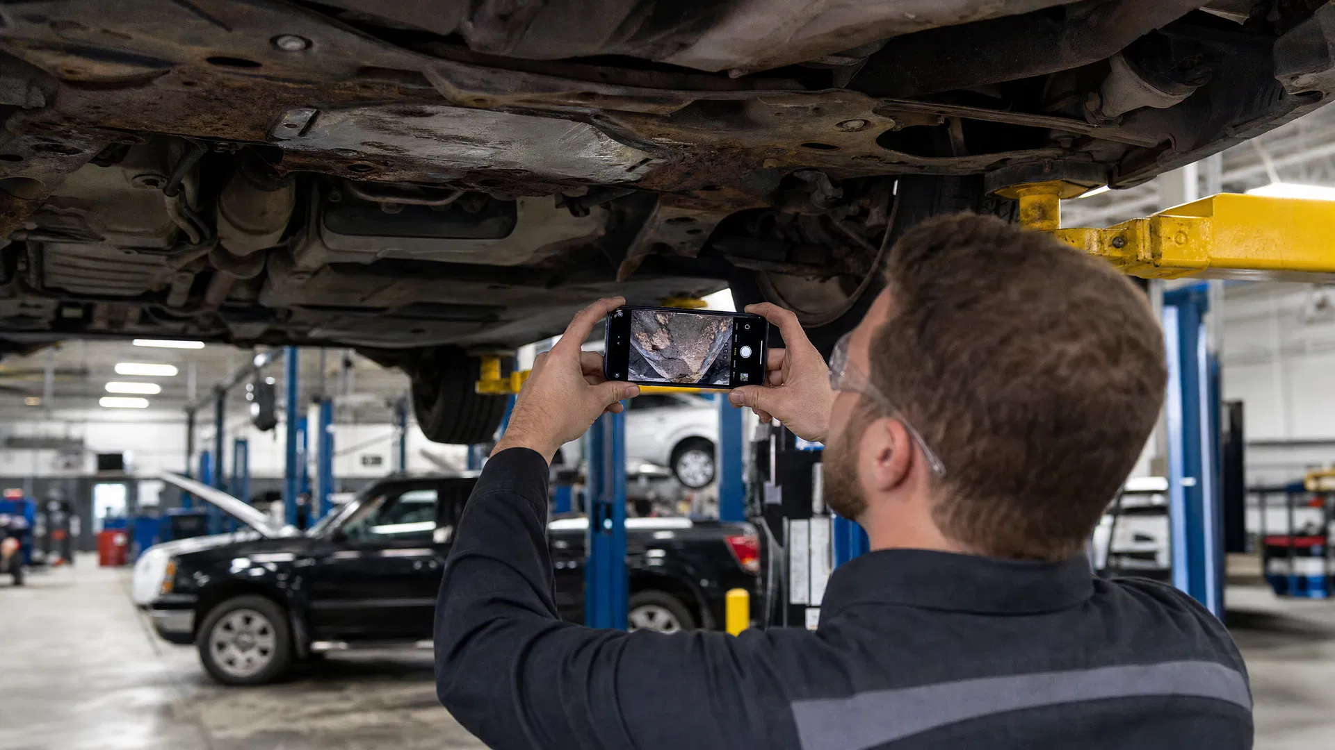 Technician using workshop management software for digital inspection