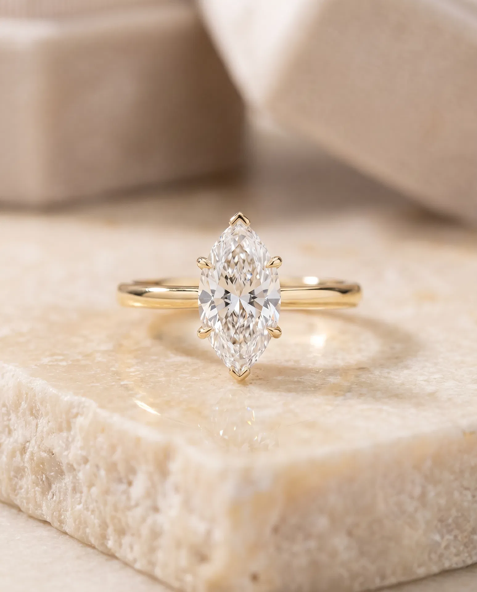 Luxury engagement ring held in a warm editorial setting