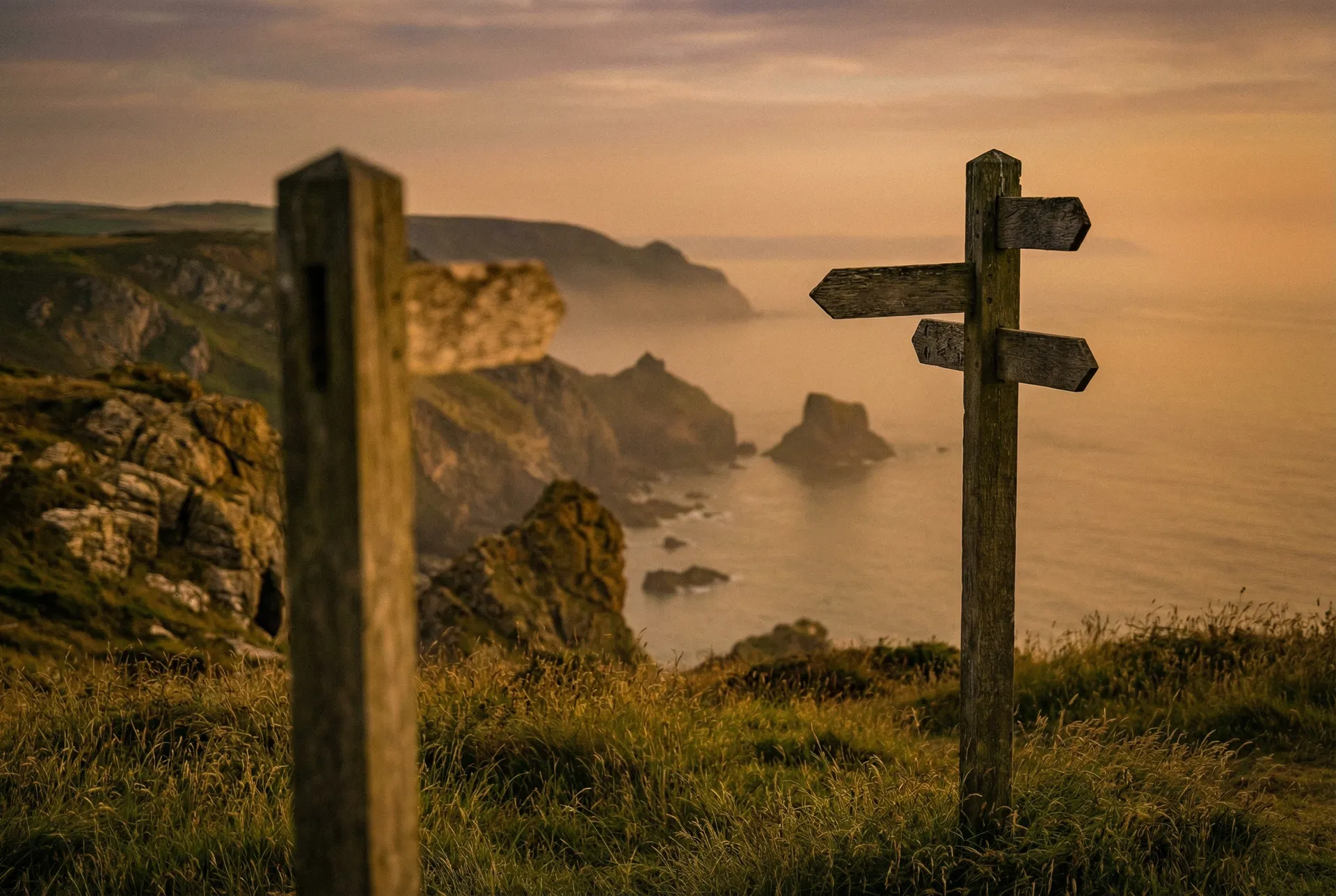 Coastal clifftop signpost at golden hour