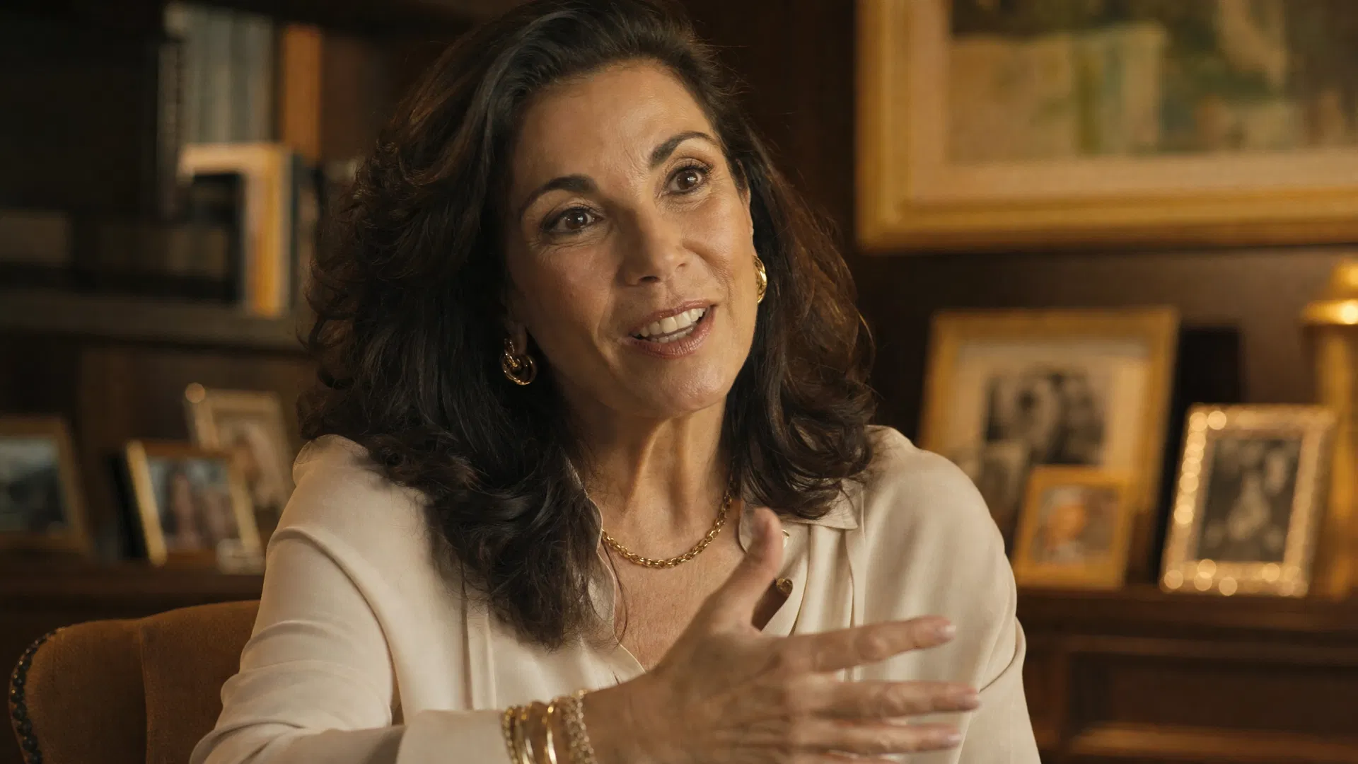 A confident woman in her mid-50s sharing her life story during a documentary interview