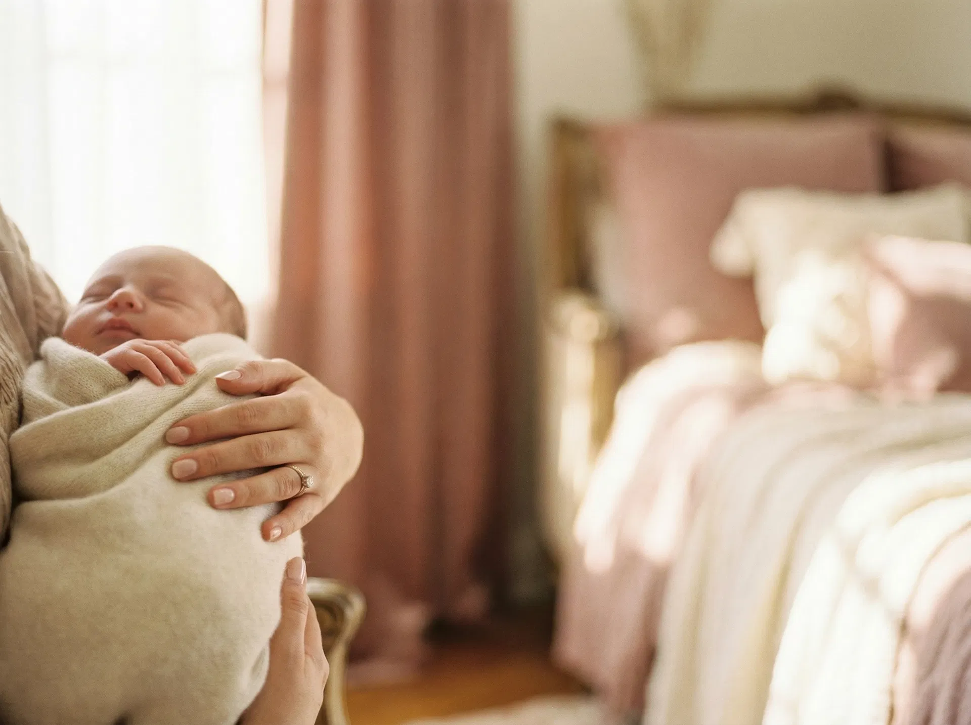 Mother holding newborn baby in warm light