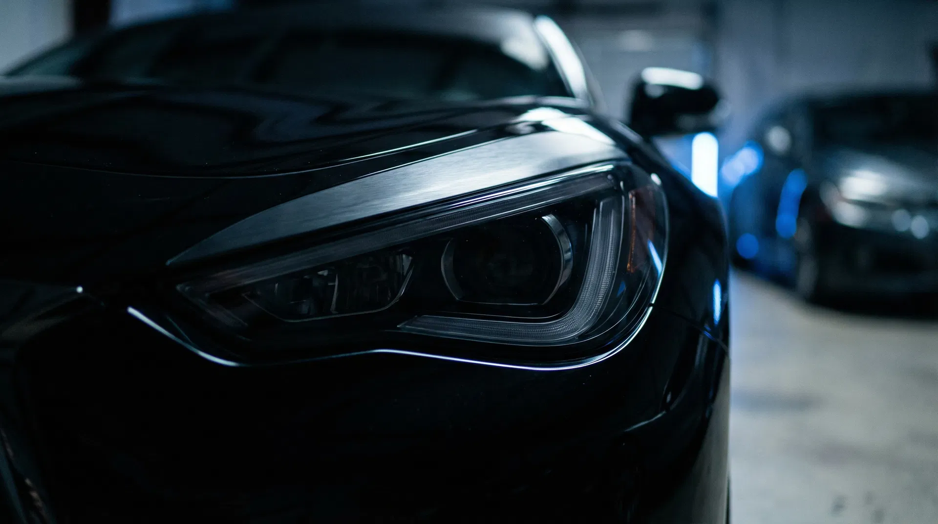 Close-up of professionally tinted headlight on a dark sports car
