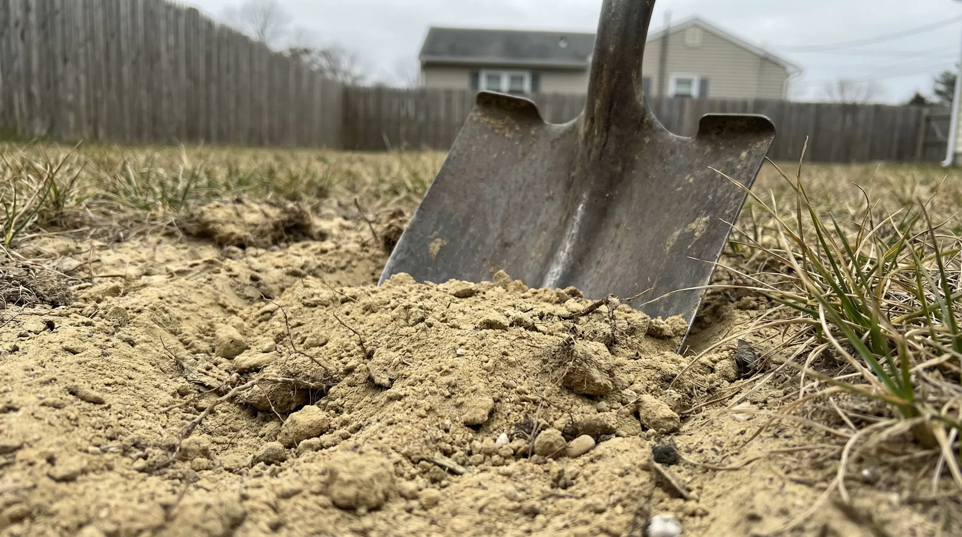 Poor sandy New Jersey soil being dug up before composted topsoil amendment in Ocean County NJ