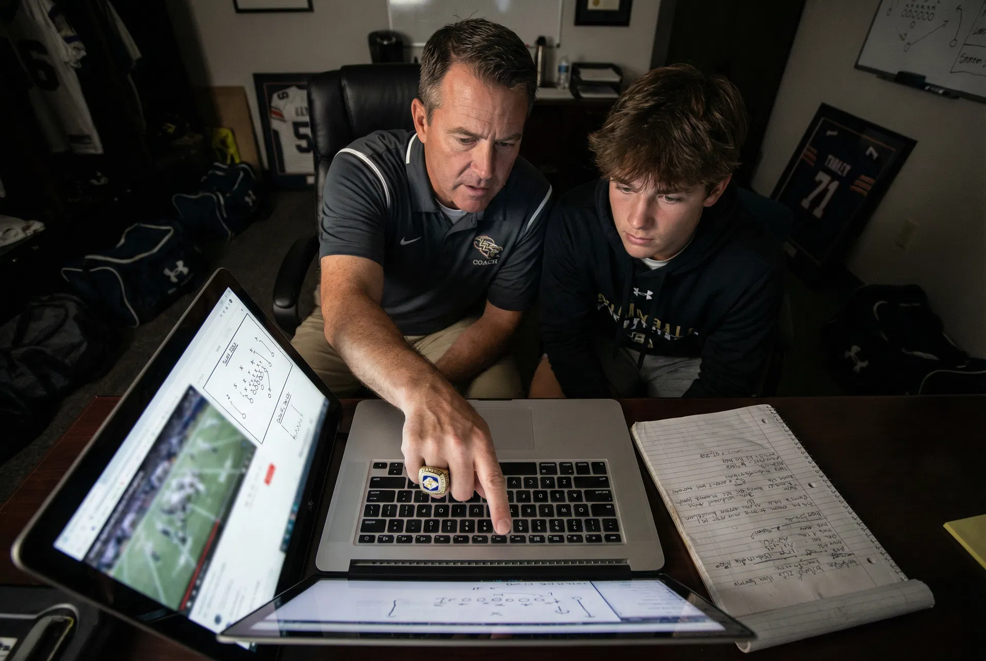 Coach reviewing film with a young offensive lineman