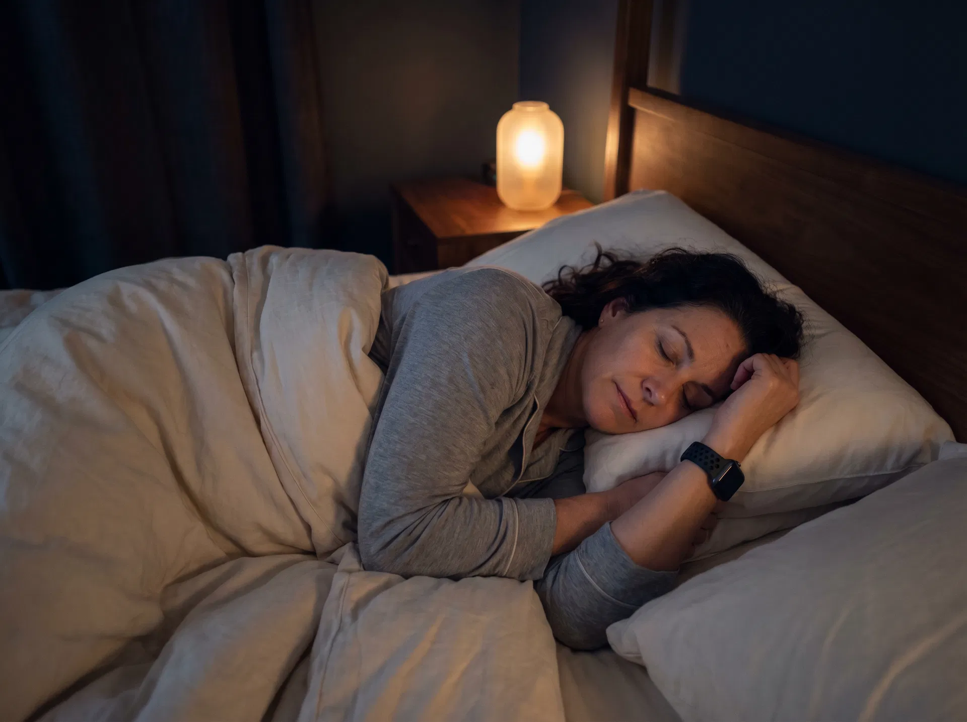 Woman in her 40s sleeping peacefully while wearing Apple Watch with NightWare