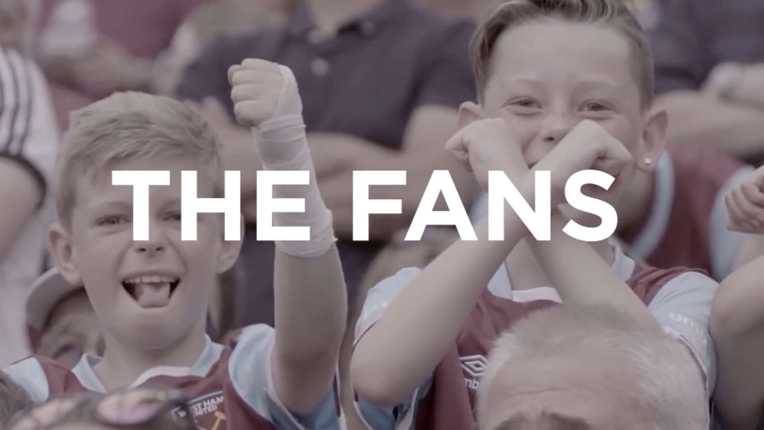 West Ham United football players are playing a game with an excited crowd.