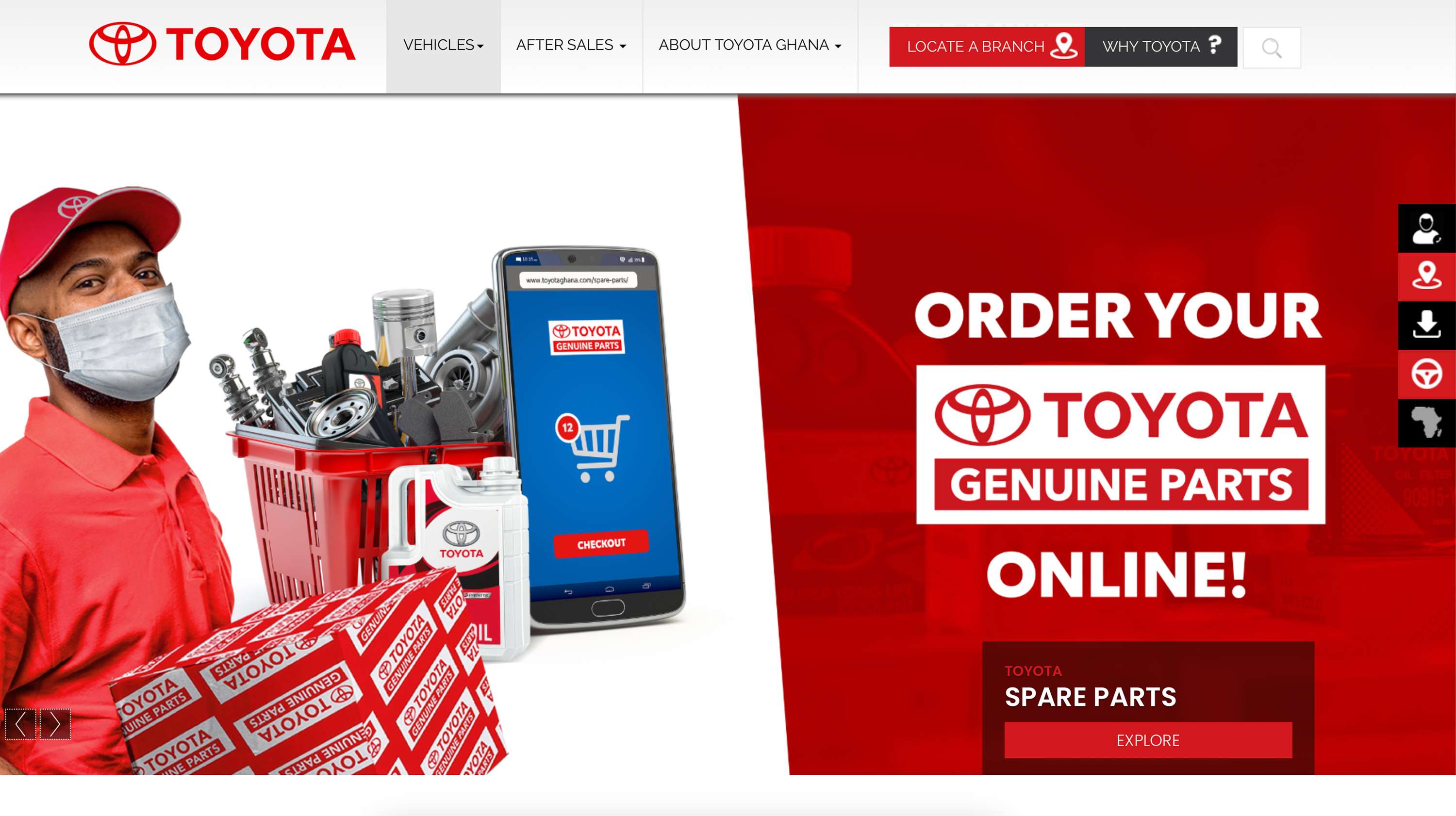A worker in a Toyota uniform, wearing a mask, stands with car parts, tools, and a phone showing online ordering.