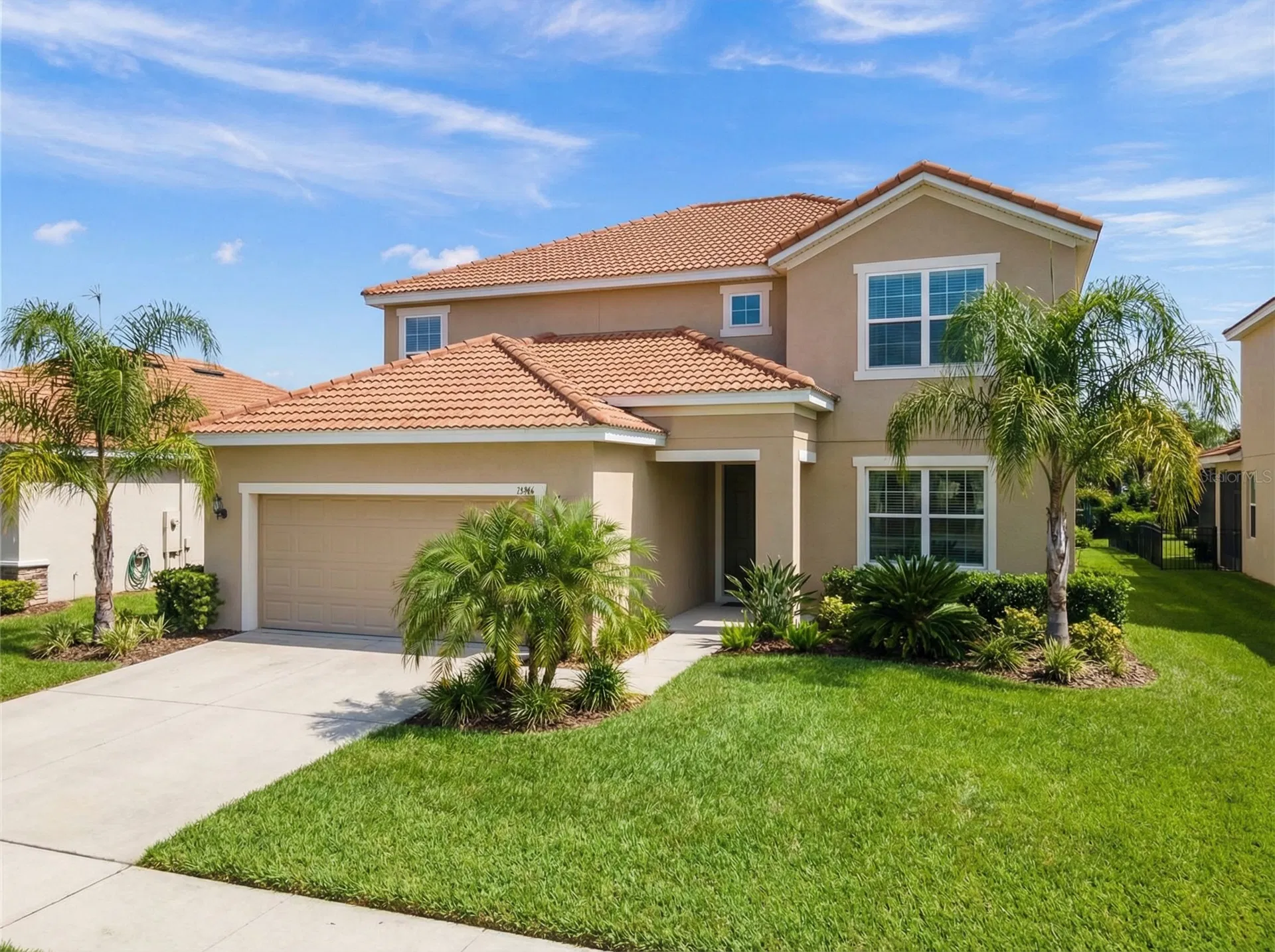 Typical two-story suburban home in Lake Nona, Florida with tile roof and palm trees