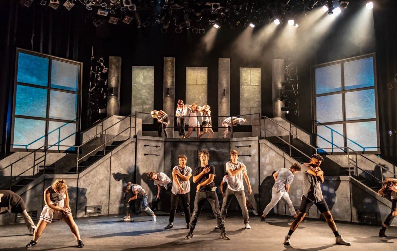 American Idiot - Scenic design by Brandon PT Davis. Gritty urban landscape with punk rock aesthetics, featuring distressed brick walls, graffiti, and dynamic lighting.