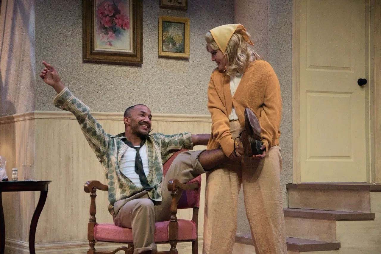 Barefoot in the Park - Scenic design by Brandon PT Davis. Cozy, slightly cluttered New York City walk-up apartment interior with a skylight, warm lighting, and period furniture, capturing the play's romantic comedy.