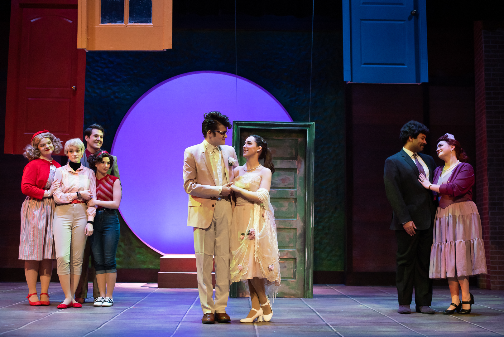 The Merry Wives of Windsor - Scenic design by Brandon PT Davis. A vibrant, traditional English village setting with colorful houses and lively market square, capturing the comedic spirit.