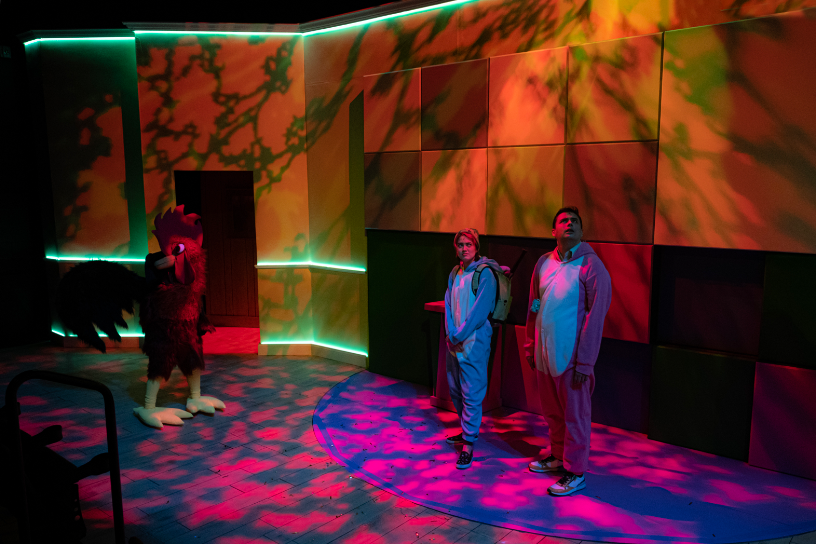 ¡LOTERIA: GAME ON! - Scenic design by Brandon PT Davis. A vibrant, game-themed suburban basement living room set.