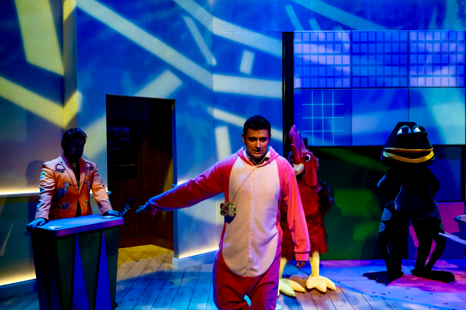 ¡LOTERIA: GAME ON! - Scenic design by Brandon PT Davis. A vibrant, game-themed suburban basement living room set.