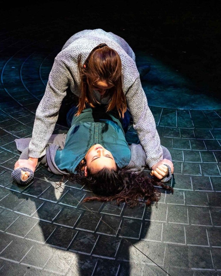 Parliament Square - Scenic design by Brandon PT Davis. A stark, urban setting with towering grey structures and a central public space, evoking a sense of political tension.