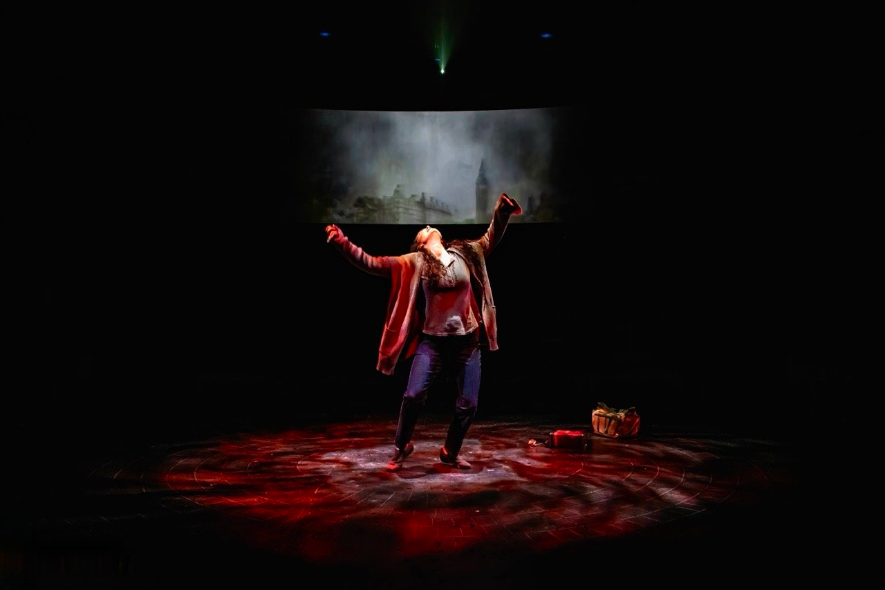 Parliament Square - Scenic design by Brandon PT Davis. A stark, minimalist set with a towering backdrop, muted colors, and dramatic lighting, evoking political tension.