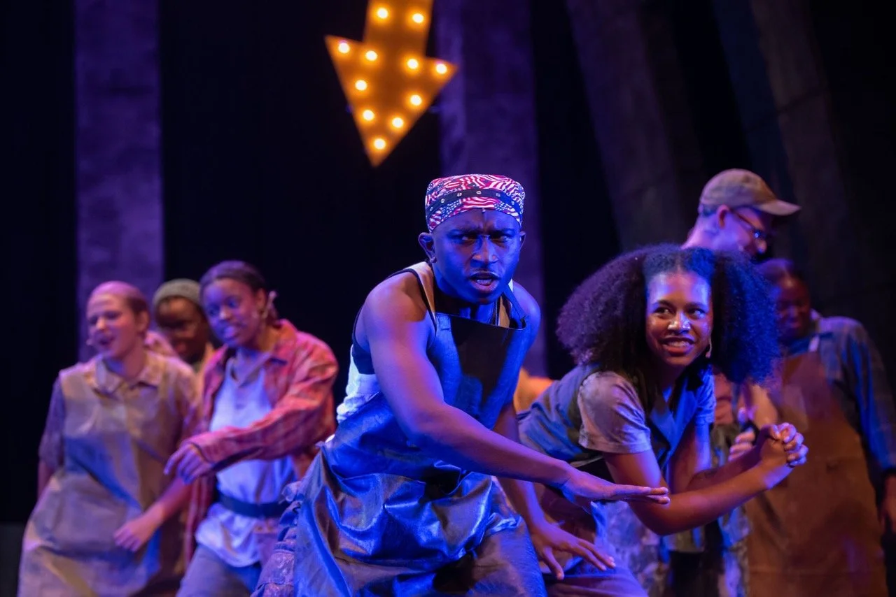 Urinetown - Scenic design by Brandon PT Davis. Industrial, multi-level set with stark, oppressive architecture and muted colors, reflecting a dystopian society.