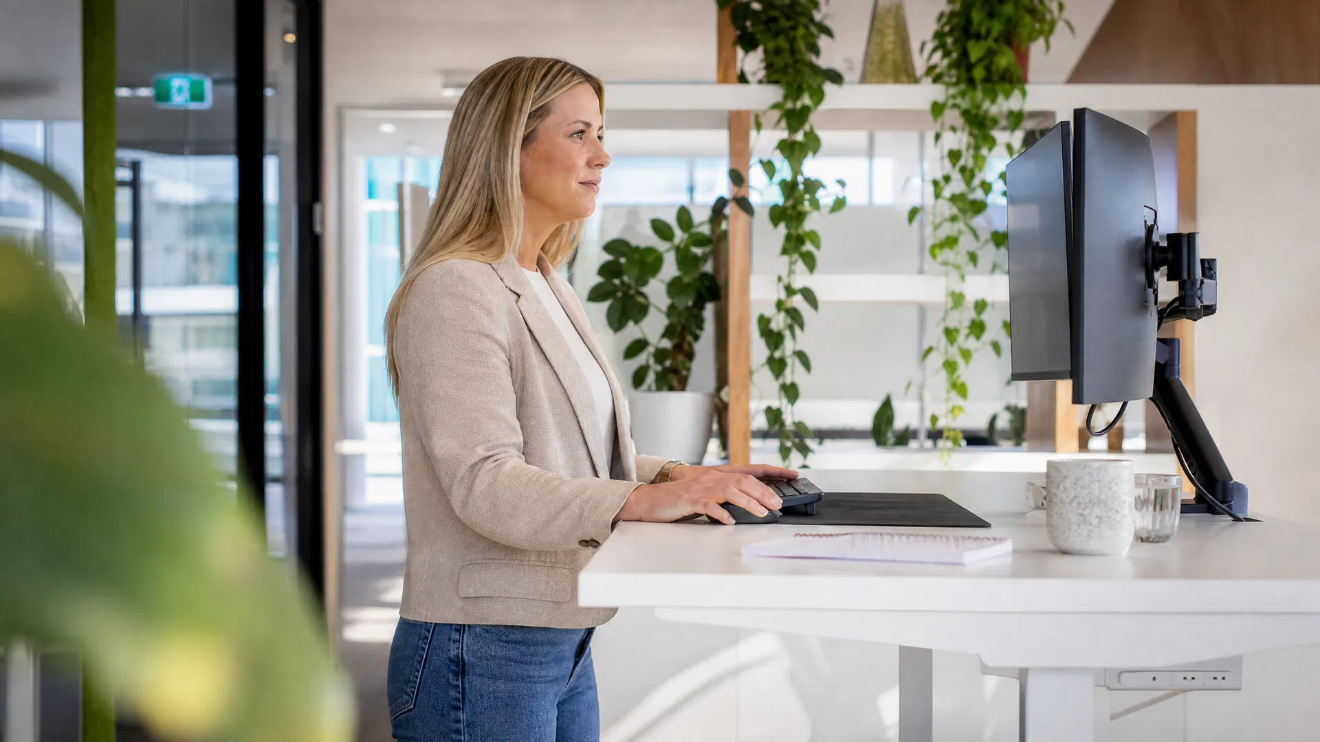 Woman working at a standing desk in a modern Australian office with good posture