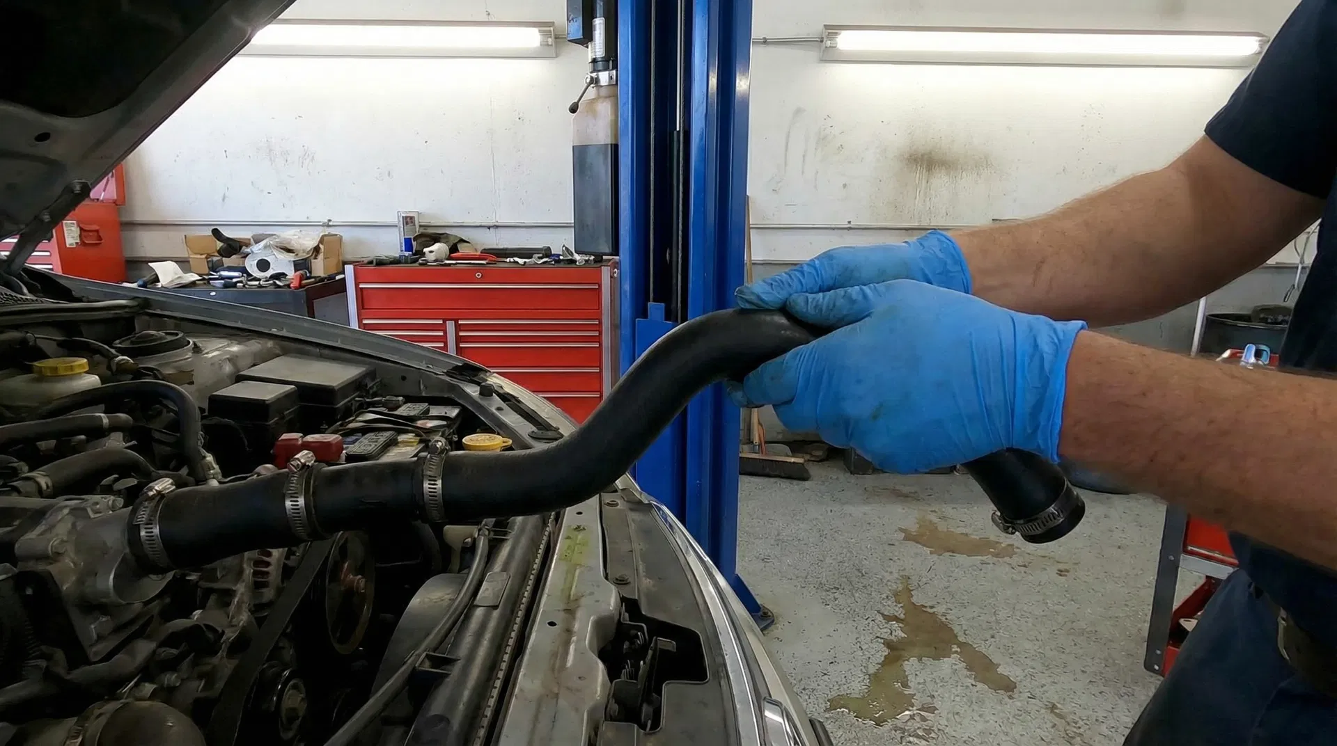 Mechanic inspecting coolant hoses